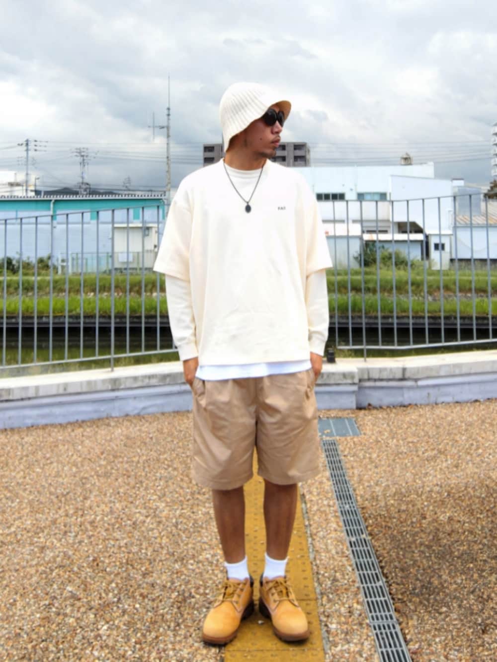 ホワイト系のTシャツ/カットソー、ホワイト系のタンクトップ、ベージュ系のチノパンツを着用したメンズの秋コーディネートの2枚目の写真