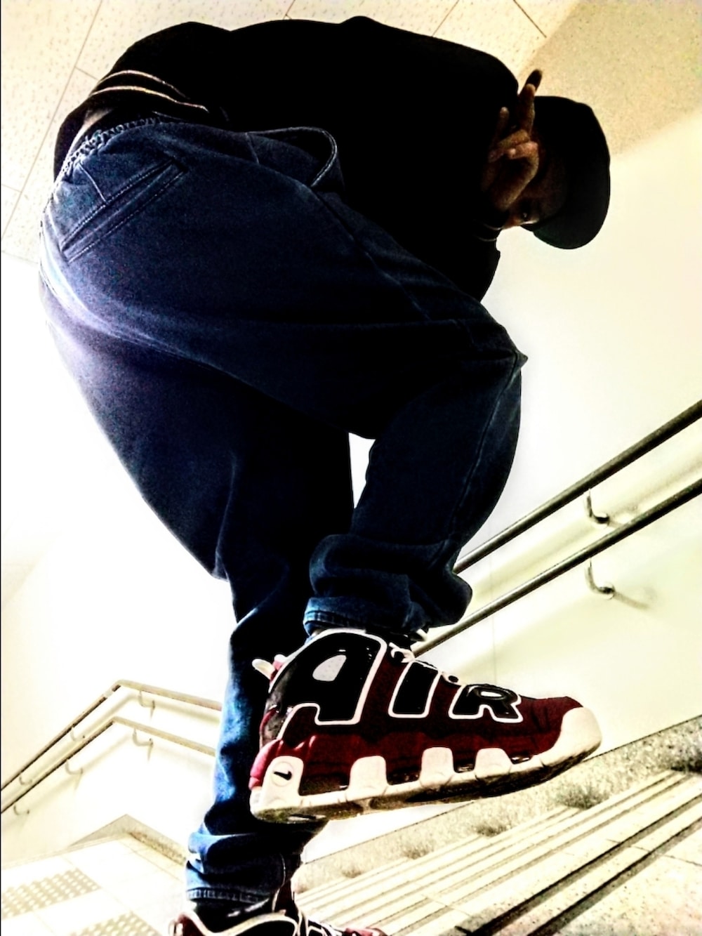 ブラック系のスウェット、ブルー系のデニムパンツ、レッド系のスニーカーを着用したメンズの秋コーディネートの3枚目の写真