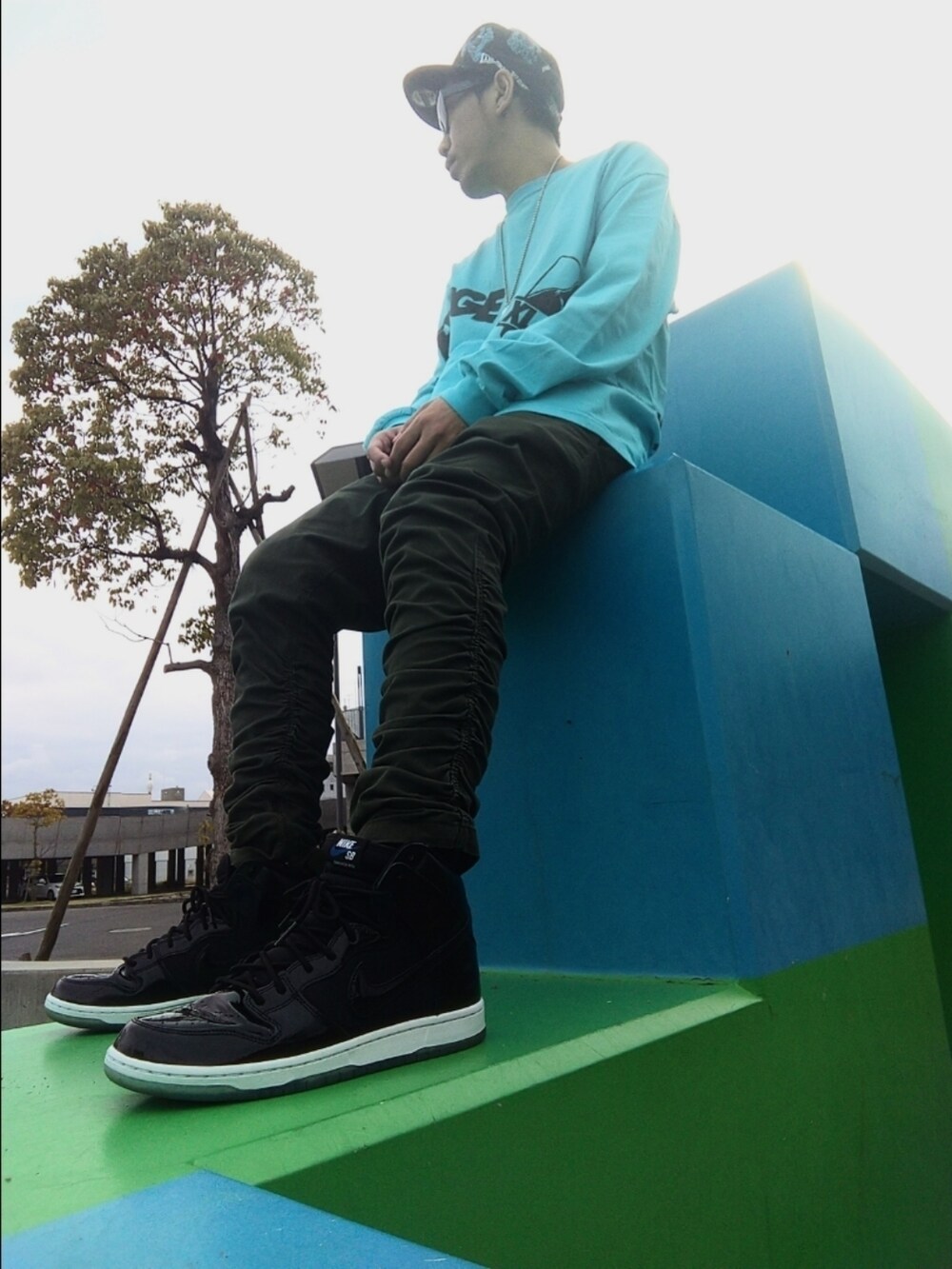 ブルー系のTシャツ/カットソー、ブラック系のスニーカー、グリーン系のパンツを着用したメンズの春コーディネートの4枚目の写真