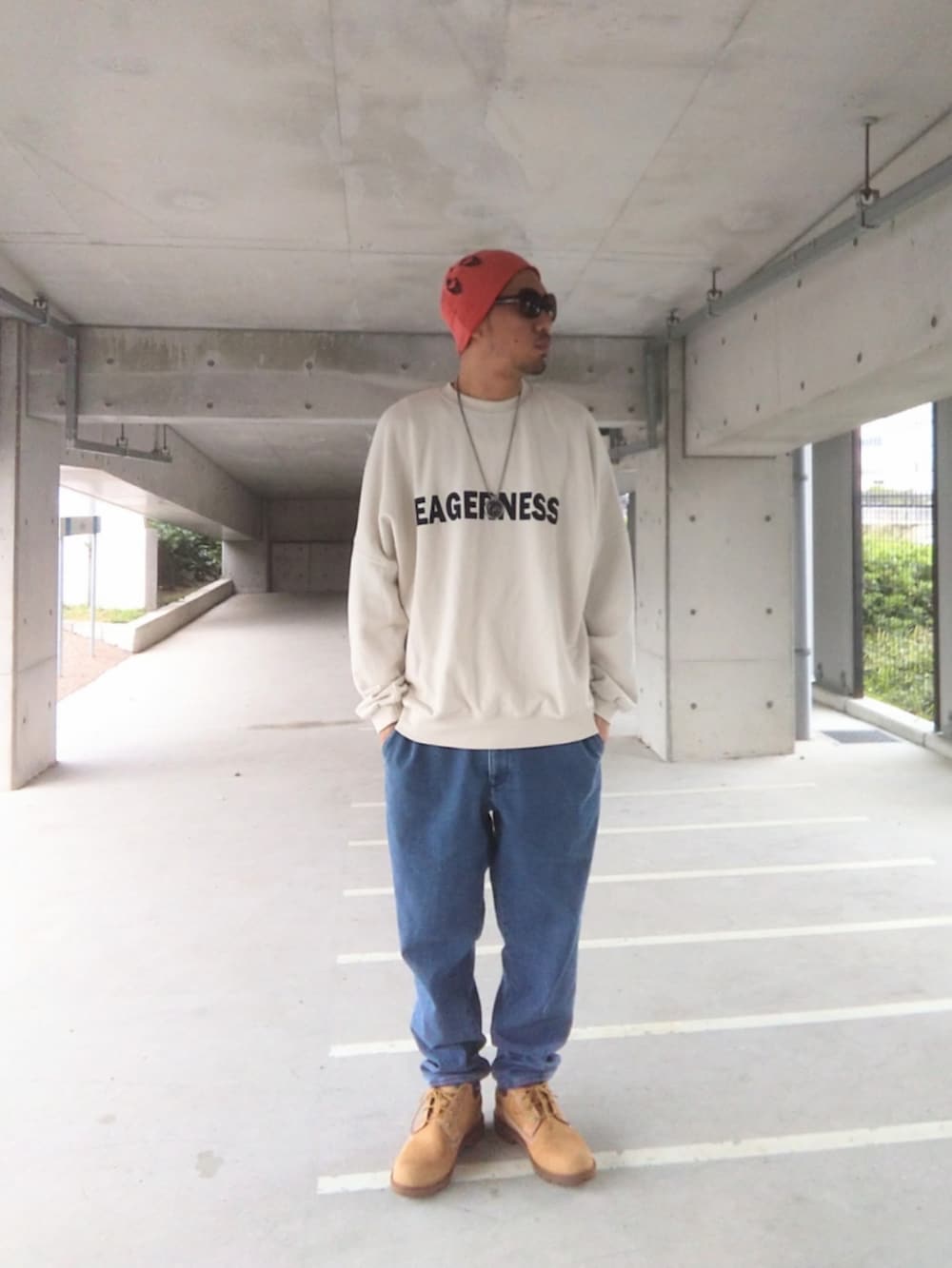 ホワイト系のスウェット、ブルー系のデニムパンツ、イエロー系のブーツを着用したメンズの秋コーディネートの2枚目の写真