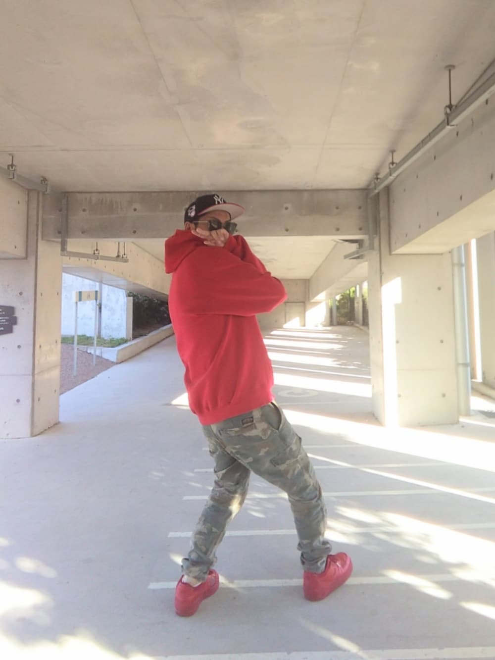 レッド系のパーカー、その他のカーゴパンツ、レッド系のスニーカーを着用したメンズの冬コーディネートの2枚目の写真