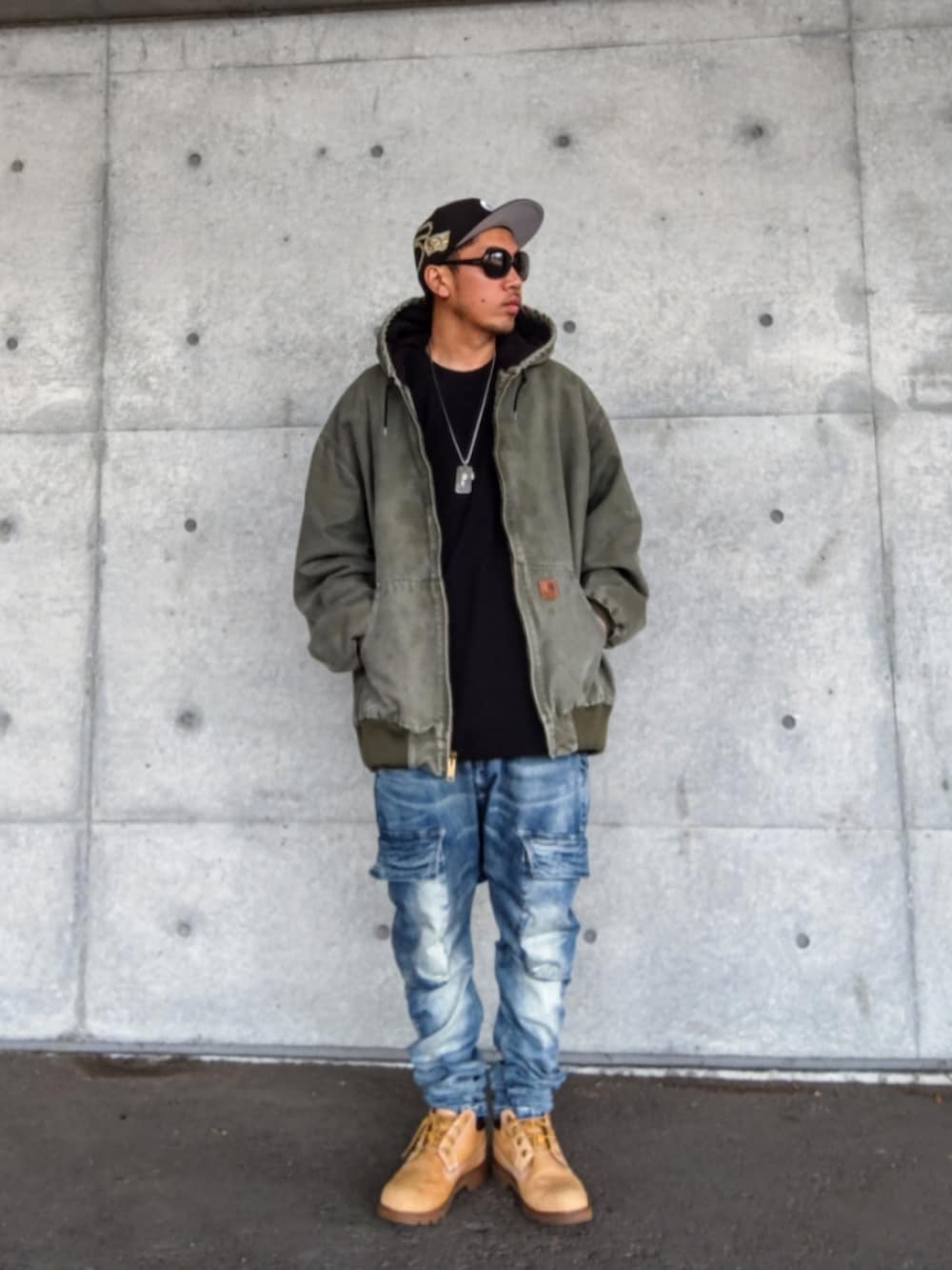 グリーン系のジャケット/アウター、ブラック系のTシャツ/カットソー、ブルー系のデニムパンツを着用したメンズの秋コーディネートの3枚目の写真