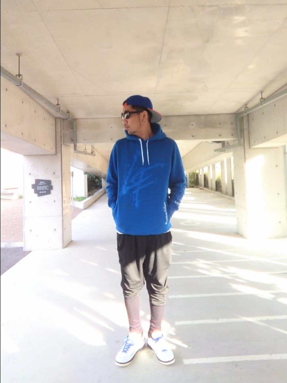 ブルー系のパーカー、ブラック系のその他パンツ、ホワイト系のスニーカーを着用したメンズの冬コーディネートの2枚目の写真