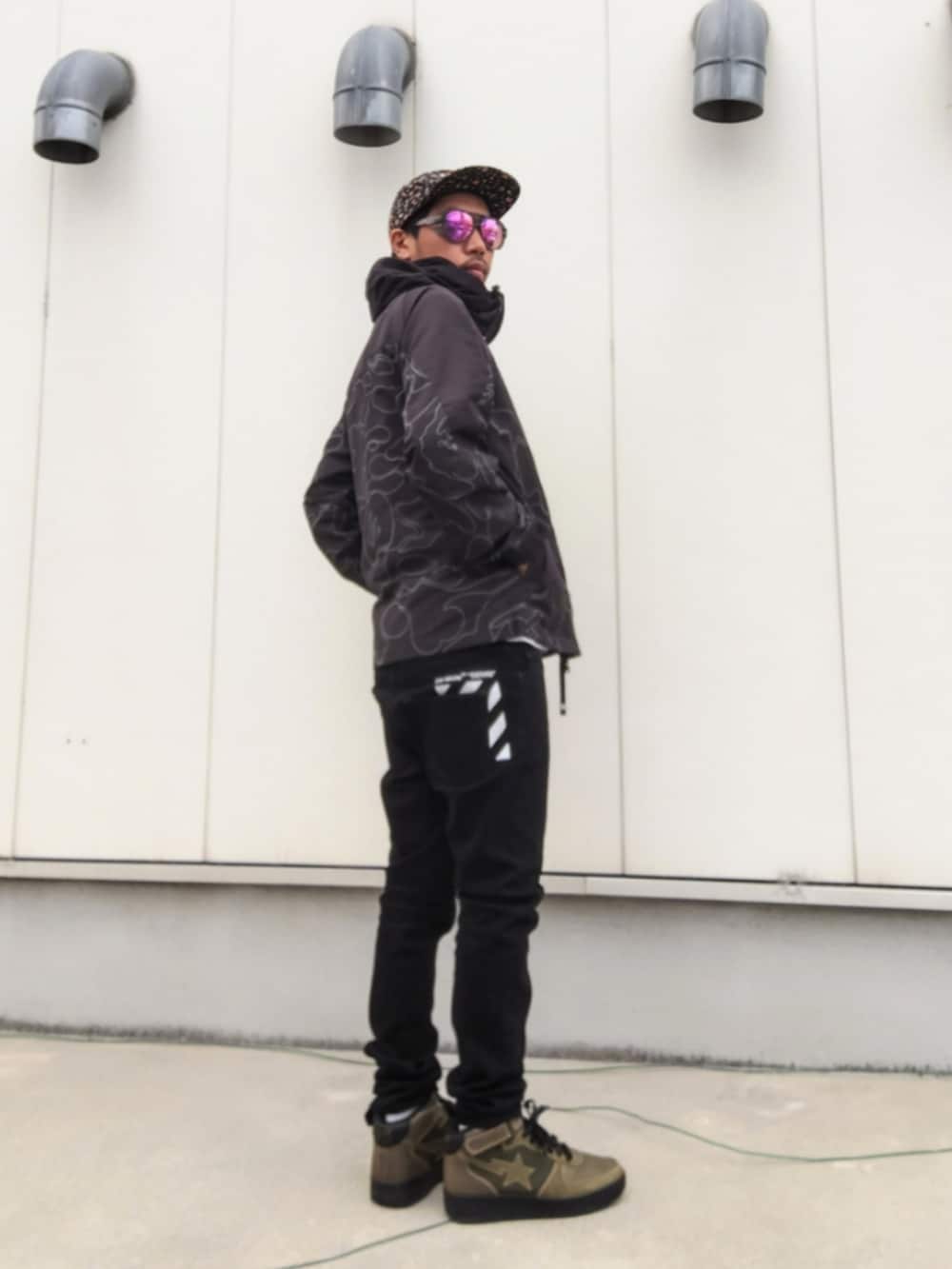 ブラック系のミリタリージャケット、ブラック系のデニムパンツ、グリーン系のスニーカーを着用したメンズの冬コーディネートの2枚目の写真