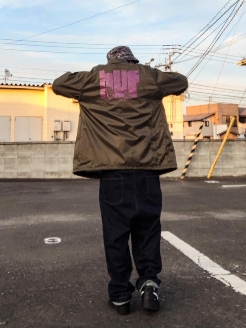 グリーン系のブルゾン、ホワイト系のTシャツ/カットソー、ブルー系のデニムパンツを着用したメンズの冬コーディネートの3枚目の写真