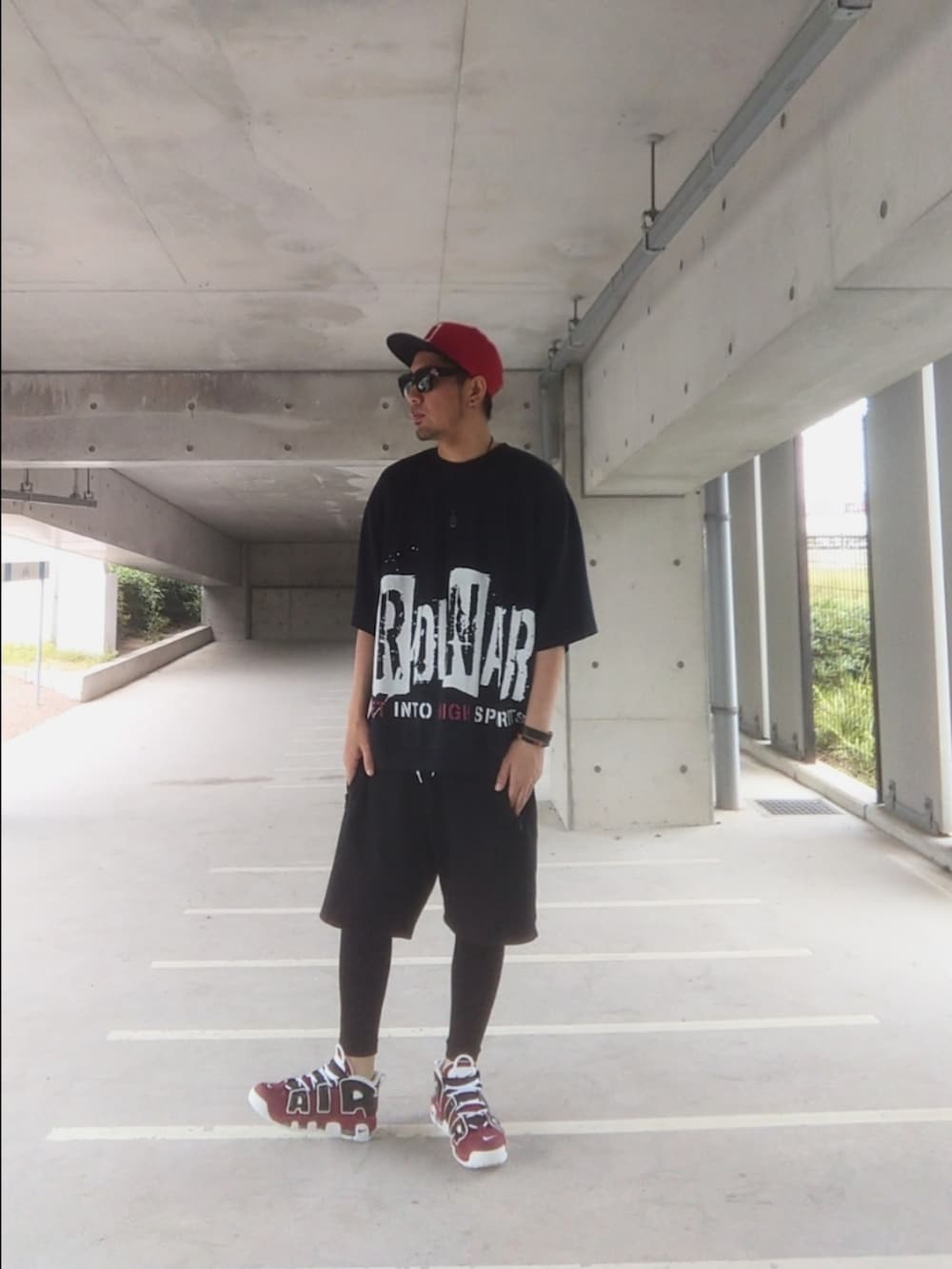 レッド系のスニーカー、ブラック系のTシャツ/カットソー、ブラック系のその他パンツを着用したメンズの春コーディネートの2枚目の写真