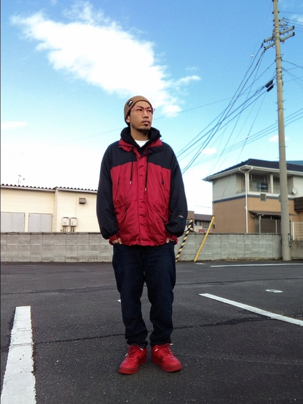 レッド系のその他アウター、ブルー系のデニムパンツ、レッド系のスニーカーを着用したメンズの冬コーディネートの3枚目の写真