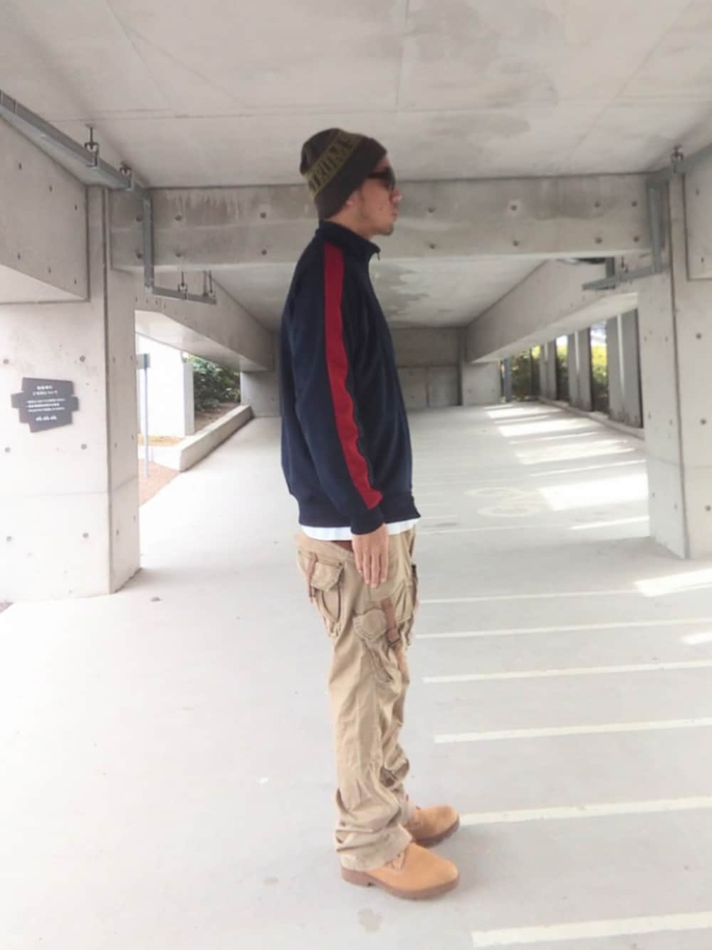 ブルー系のジャージ、ベージュ系のカーゴパンツ、イエロー系のブーツを着用したメンズの春コーディネートの3枚目の写真