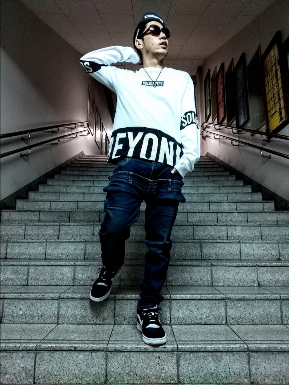 ホワイト系のTシャツ/カットソー、ブルー系のデニムパンツ、ブラック系のスニーカーを着用したメンズの秋コーディネートの2枚目の写真
