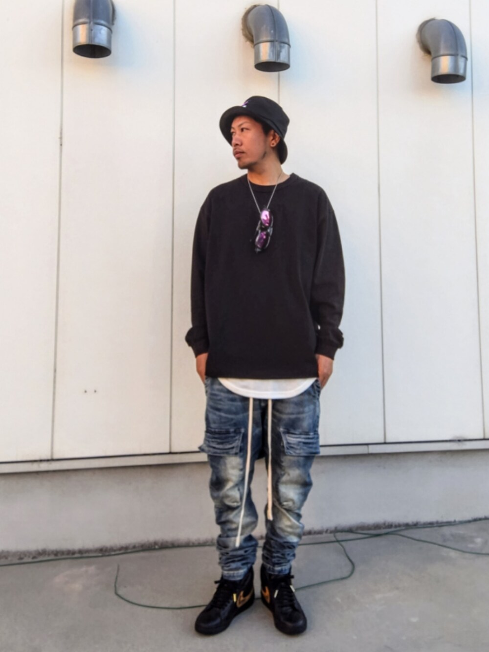 ブラック系のTシャツ/カットソー、ブルー系のデニムパンツ、ブラック系のスニーカーを着用したメンズの冬コーディネートの2枚目の写真