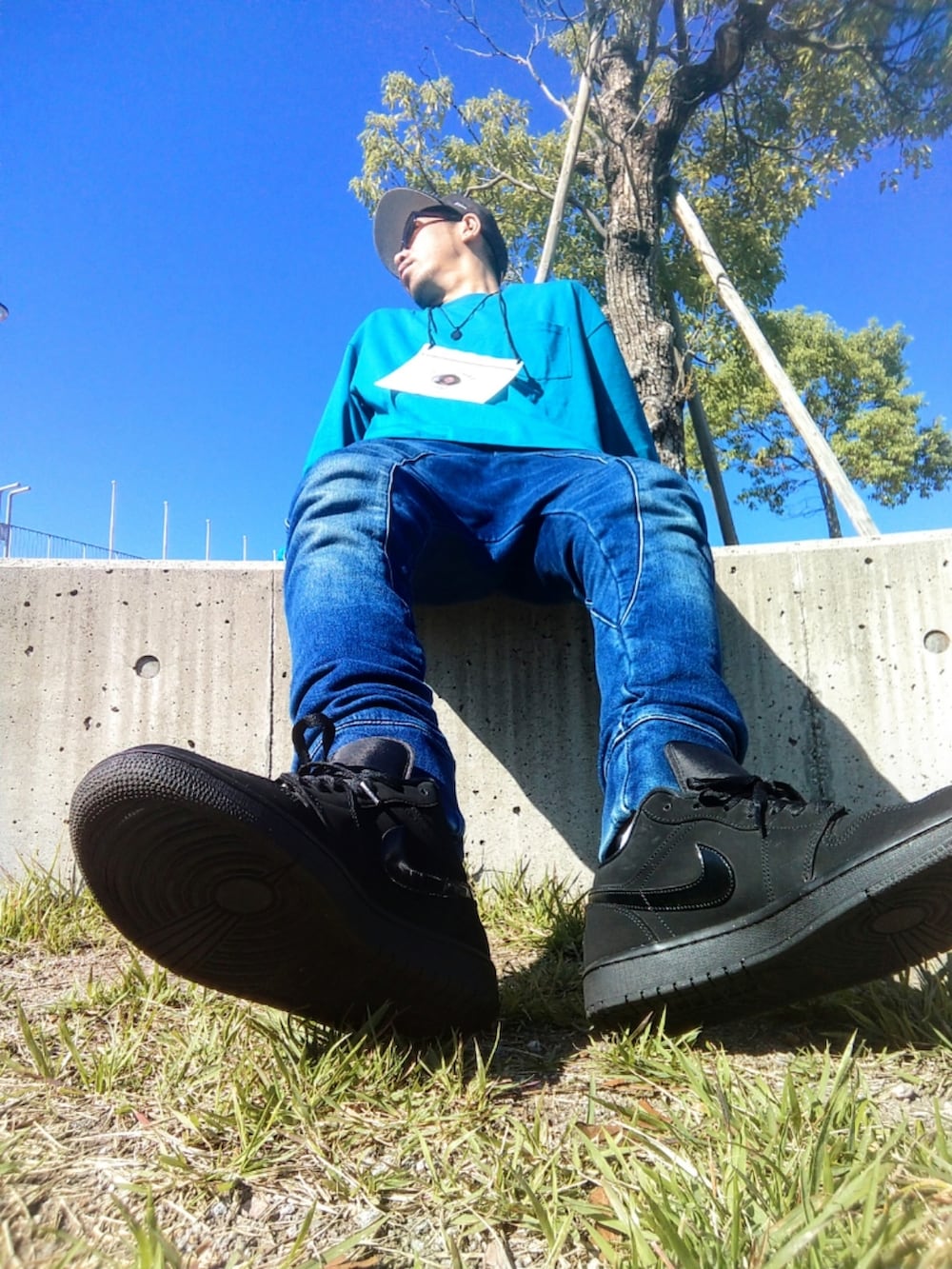 ブルー系のトップス、ブルー系のパンツ、ブラック系のスニーカーを着用したメンズの秋コーディネートの2枚目の写真