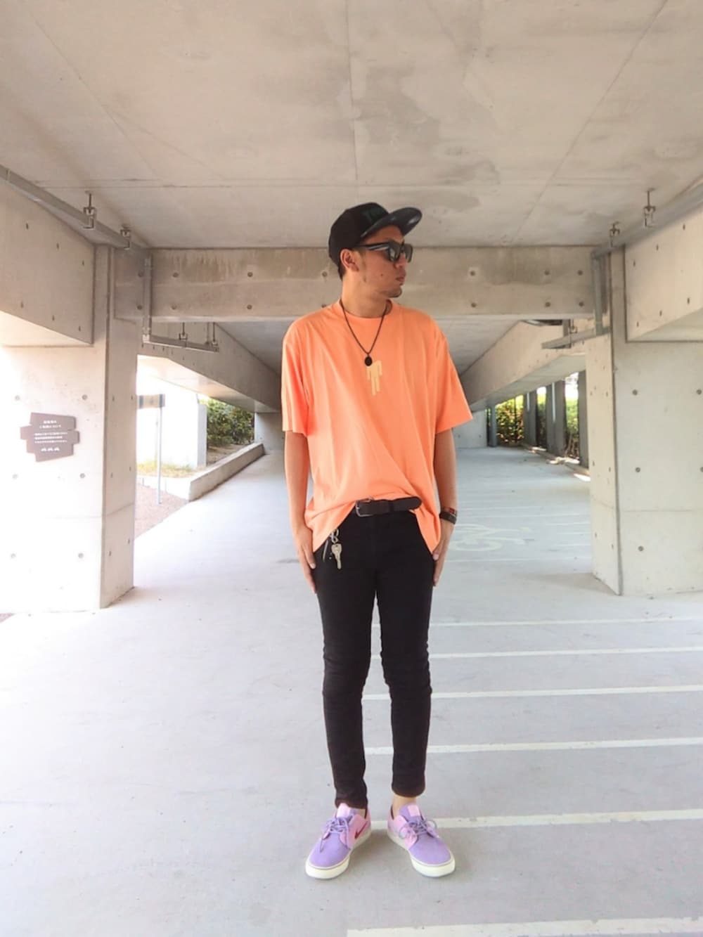 オレンジ系のTシャツ/カットソー、ブラック系のデニムパンツ、パープル系のスニーカーを着用したメンズの夏コーディネートの2枚目の写真