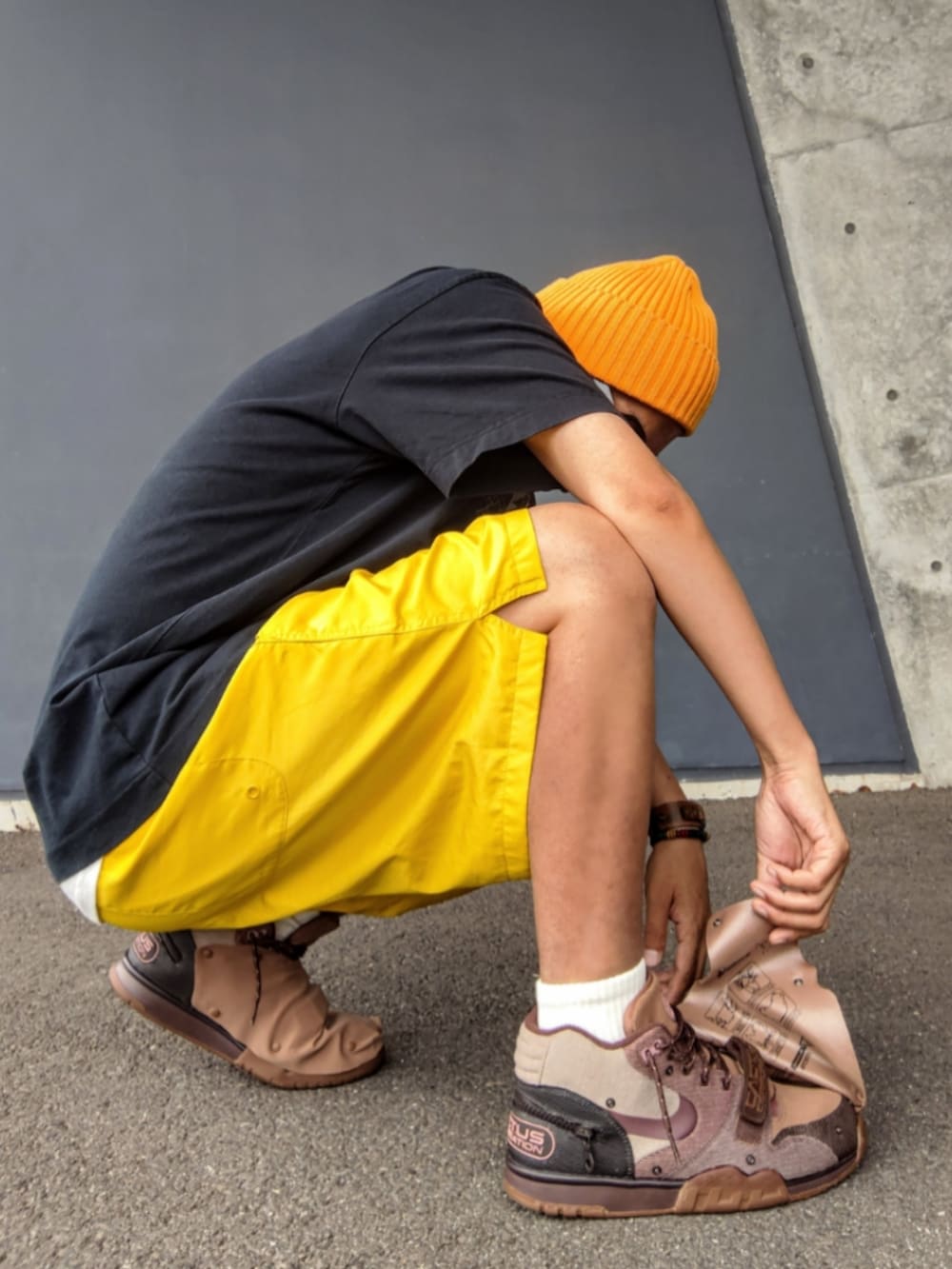 ブラック系のTシャツ/カットソー、イエロー系のその他パンツ、ブラウン系のスニーカーを着用したメンズの夏コーディネートの3枚目の写真