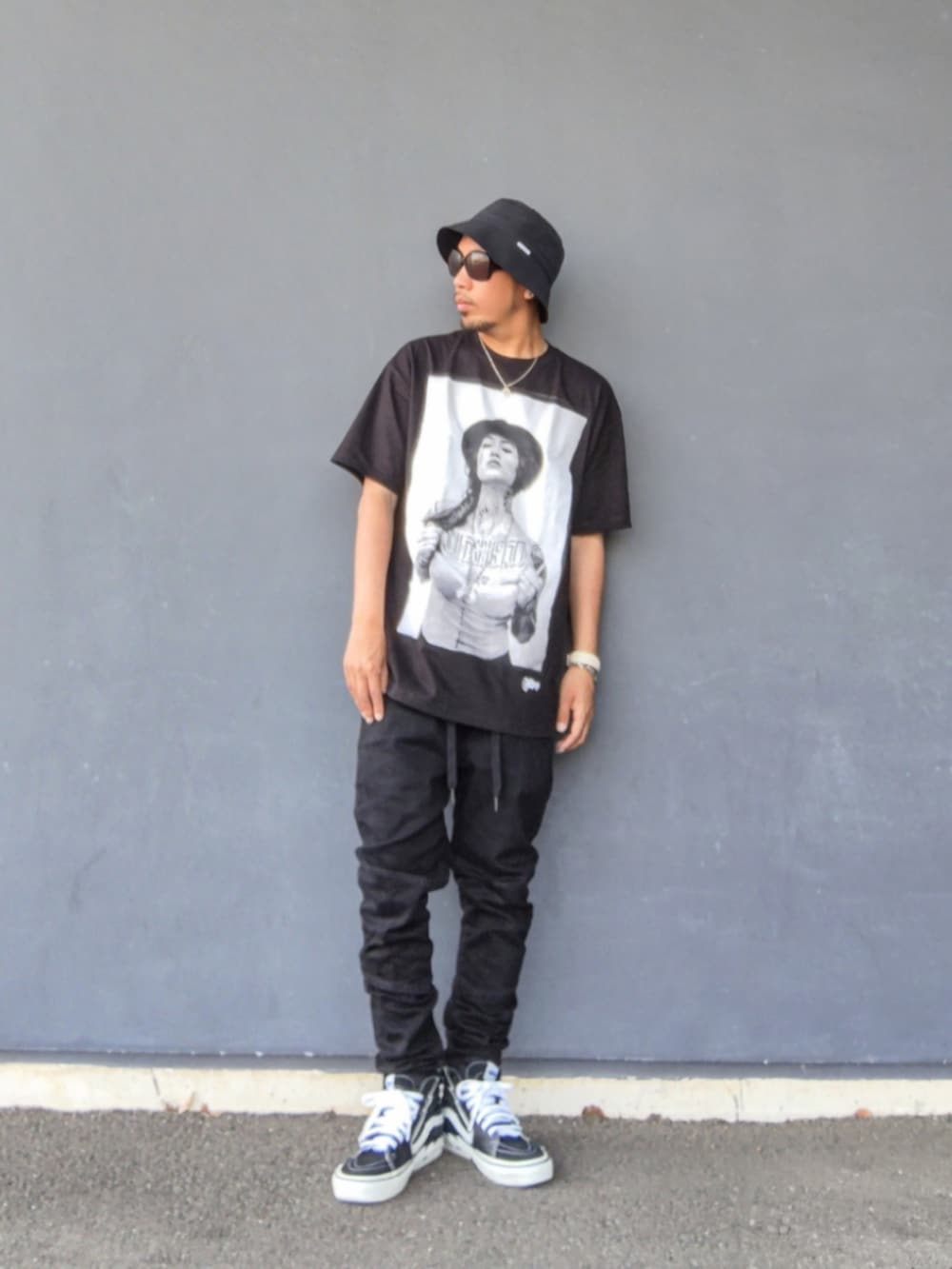 ブラック系のTシャツ/カットソー、ブラック系のデニムパンツ、ブラック系のスニーカーを着用したメンズの夏コーディネートの2枚目の写真