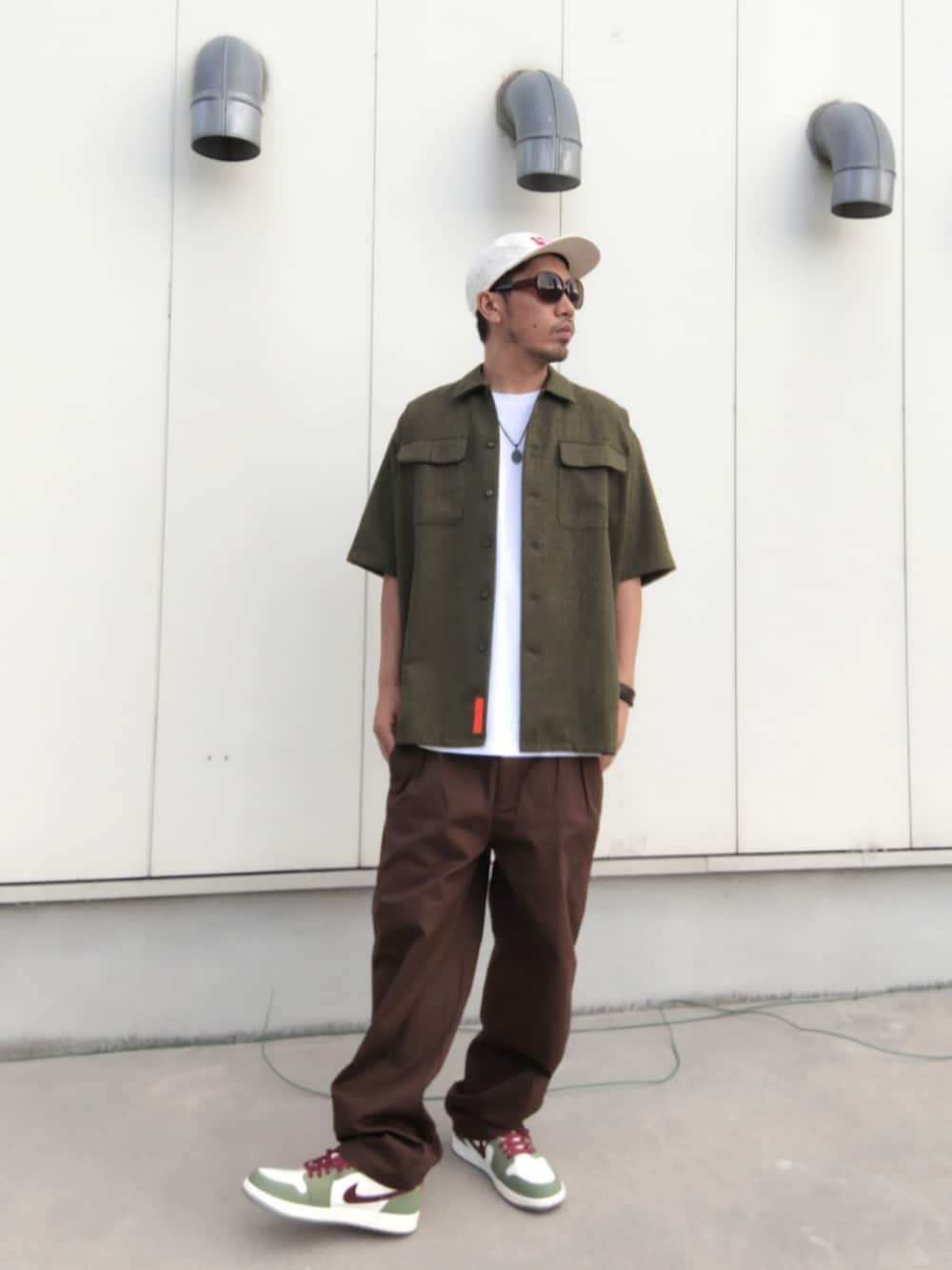 ホワイト系のTシャツ/カットソー、ブラウン系のその他パンツ、グリーン系のスニーカーを着用したメンズの夏コーディネートの2枚目の写真