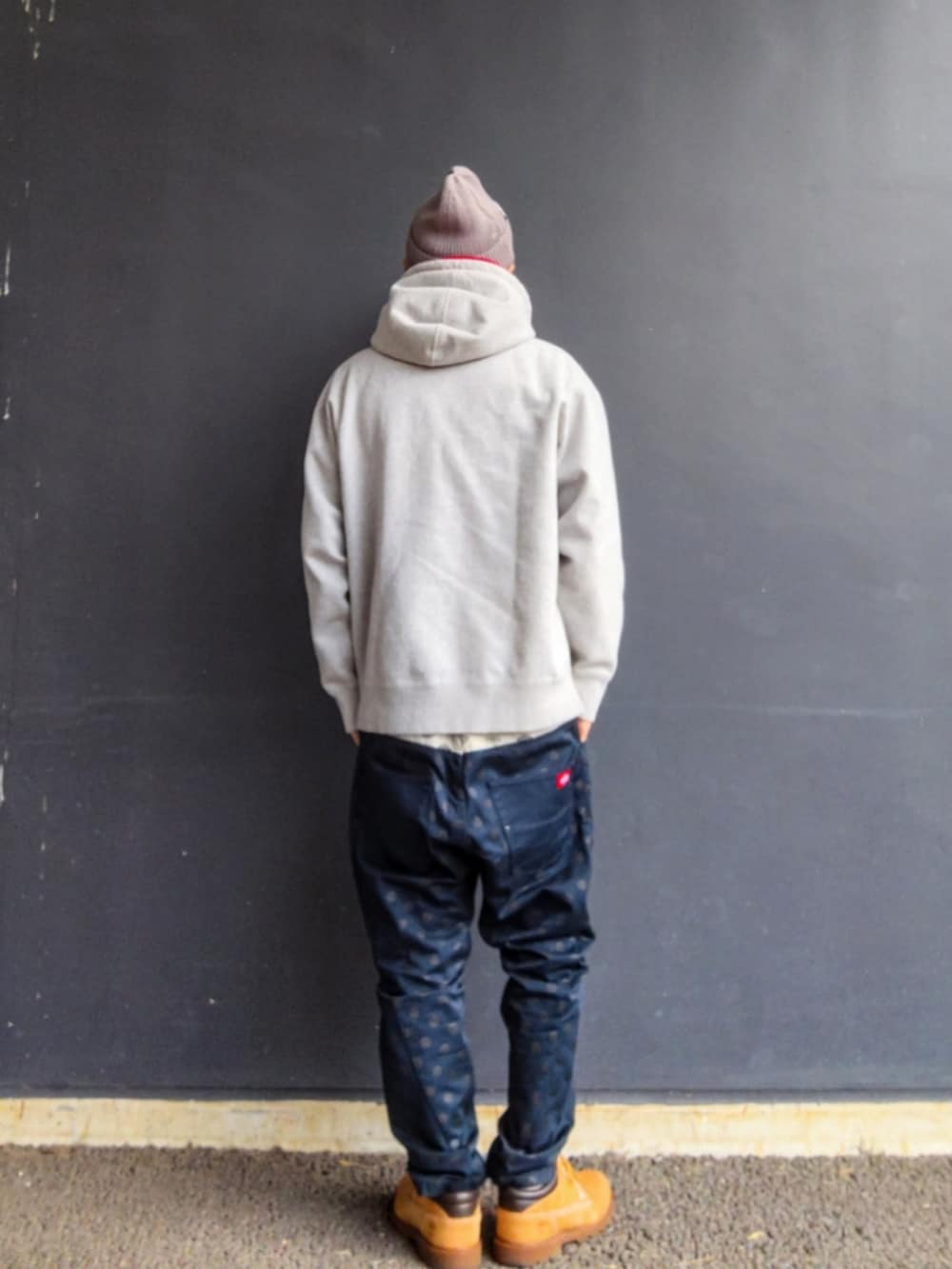 グレー系のパーカー、ブルー系のその他パンツ、イエロー系のブーツを着用したメンズの冬コーディネートの4枚目の写真