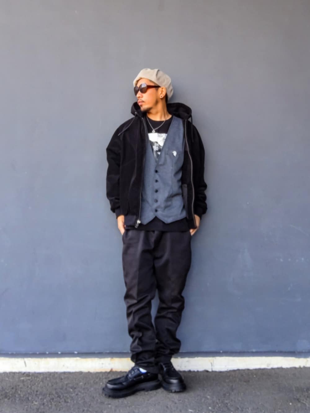 ブラック系のブルゾン、グレー系のベスト、ブラック系のTシャツ/カットソーを着用したメンズの冬コーディネートの2枚目の写真