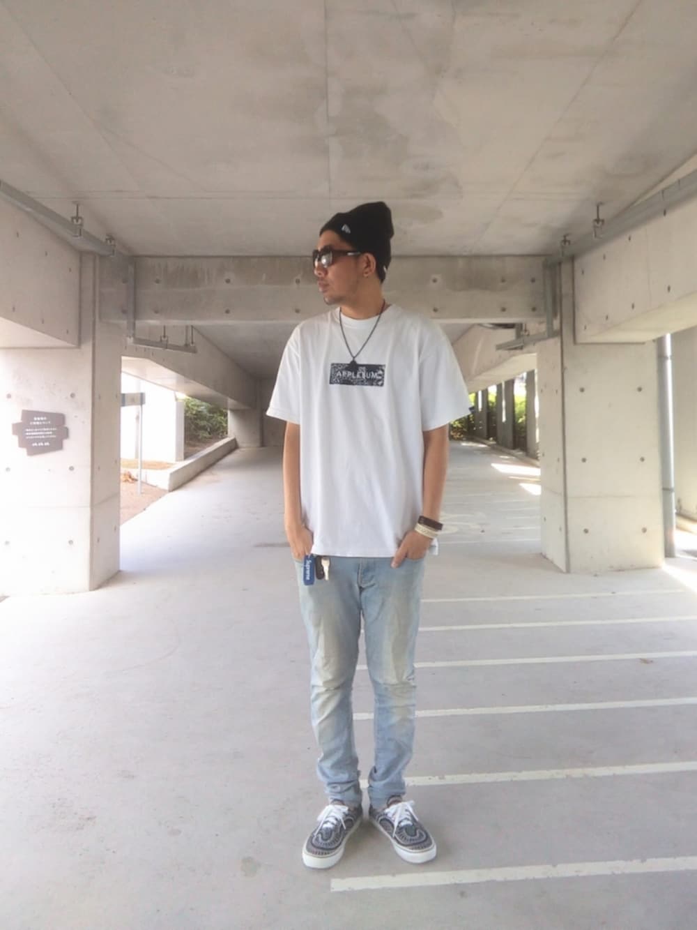 ホワイト系のTシャツ/カットソー、ブルー系のデニムパンツ、ブラック系のスニーカーを着用したメンズの秋コーディネートの2枚目の写真