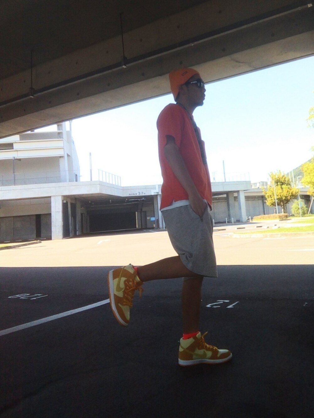 グレー系のその他パンツ、イエロー系のスニーカー、オレンジ系のTシャツ/カットソーを着用したメンズの秋コーディネートの2枚目の写真