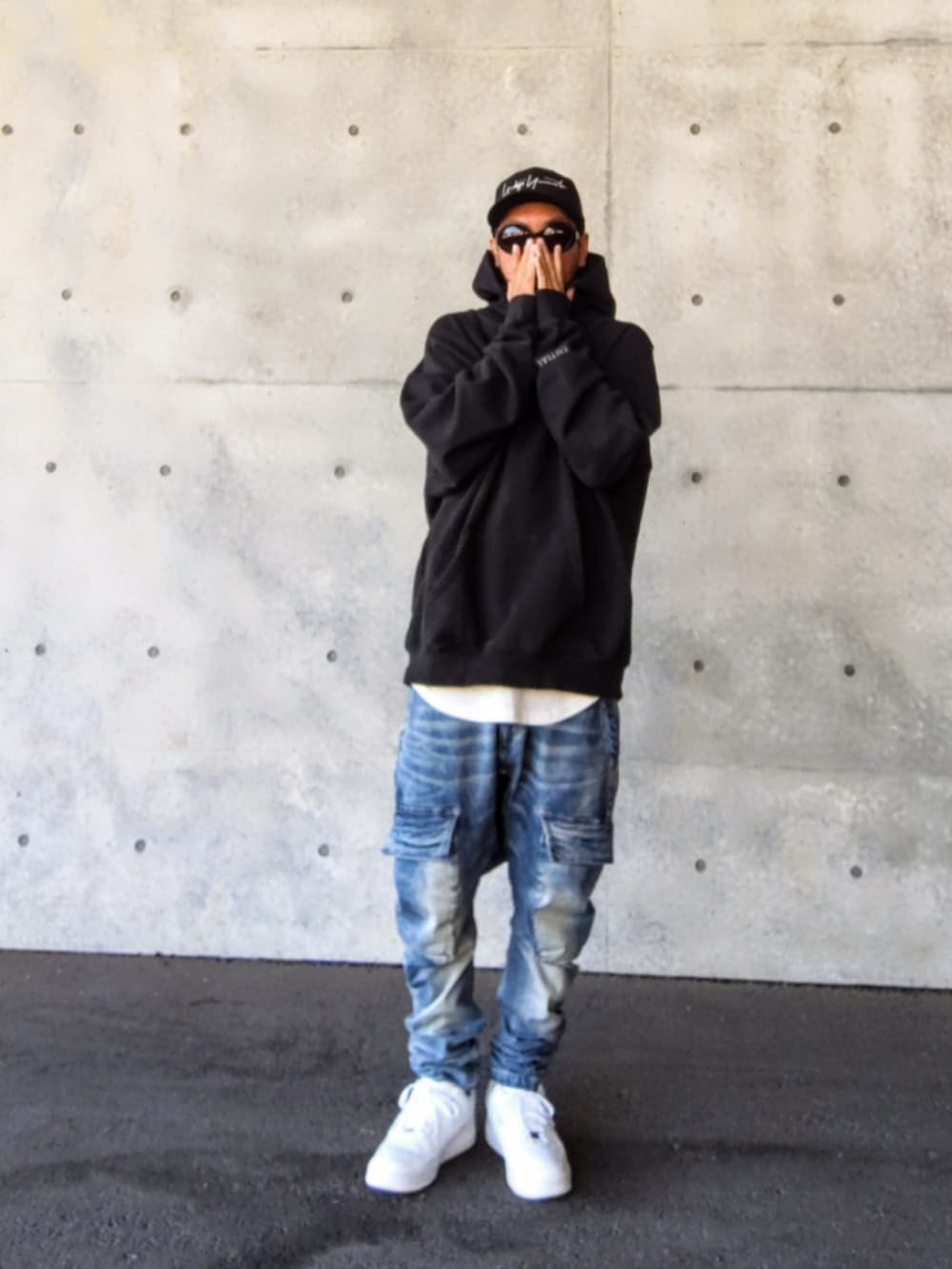 ブラック系のパーカー、ホワイト系のタンクトップ、ブルー系のデニムパンツを着用したメンズの冬コーディネートの2枚目の写真