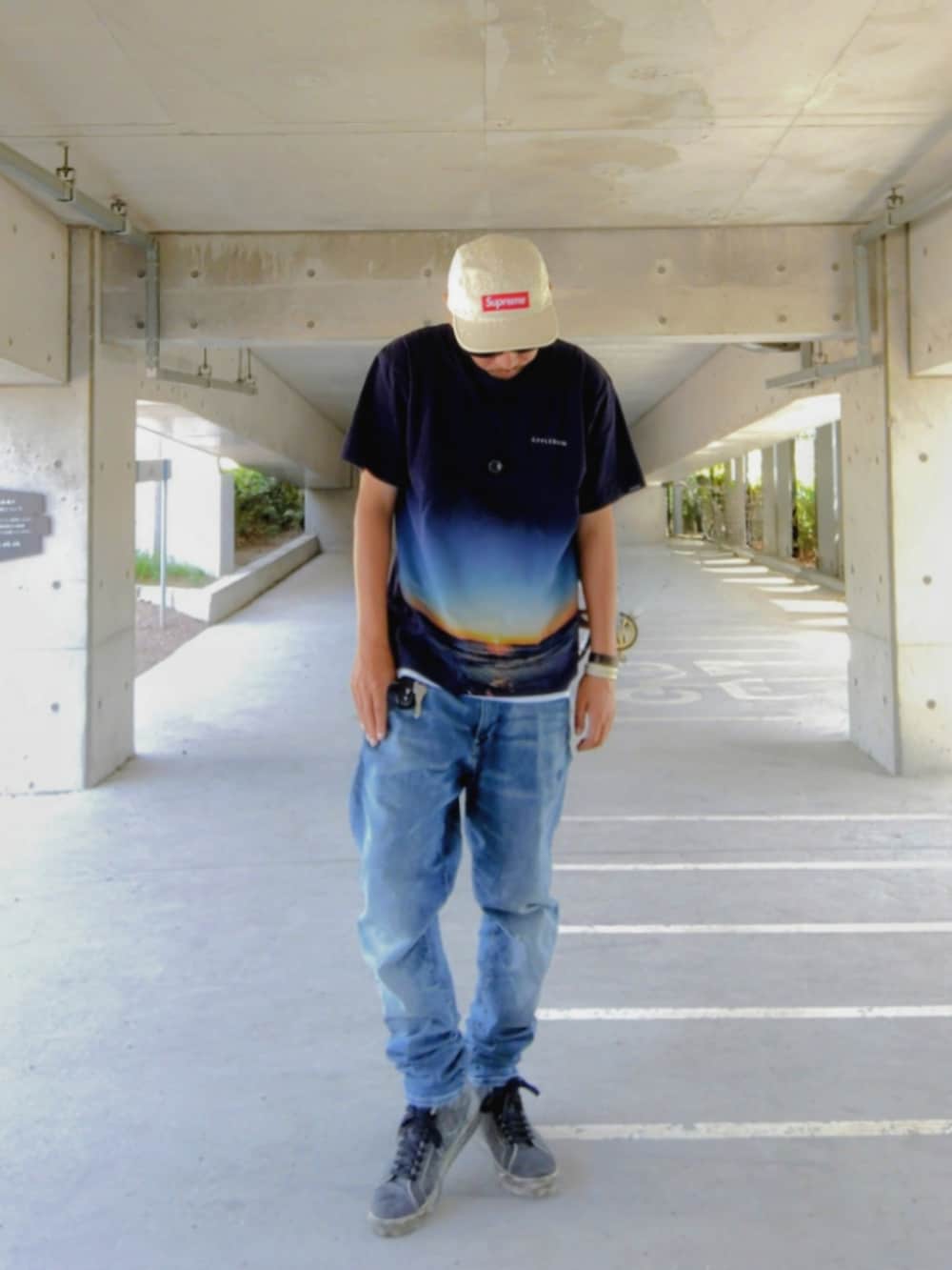 ブルー系のTシャツ/カットソー、ブルー系のデニムパンツ、ブラック系のスニーカーを着用したメンズの秋コーディネートの2枚目の写真