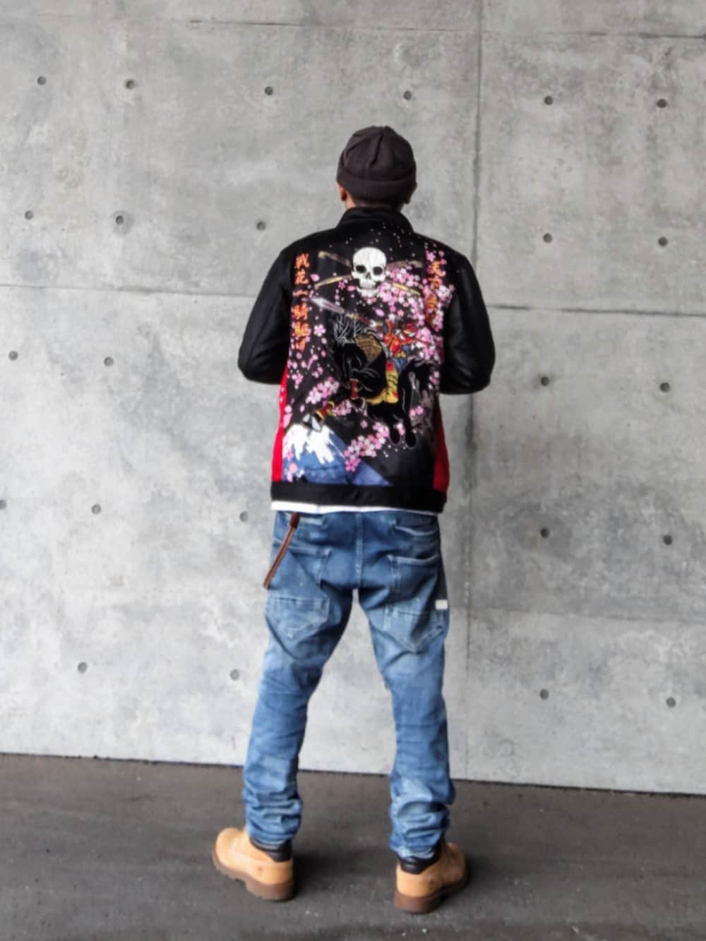 ブラック系のライダースジャケット、ブルー系のデニムパンツ、イエロー系のブーツを着用したメンズの冬コーディネートの2枚目の写真