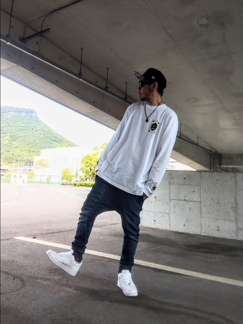 ホワイト系のTシャツ/カットソー、ブルー系のパンツ、ホワイト系のスニーカーを着用したメンズの春コーディネートの3枚目の写真