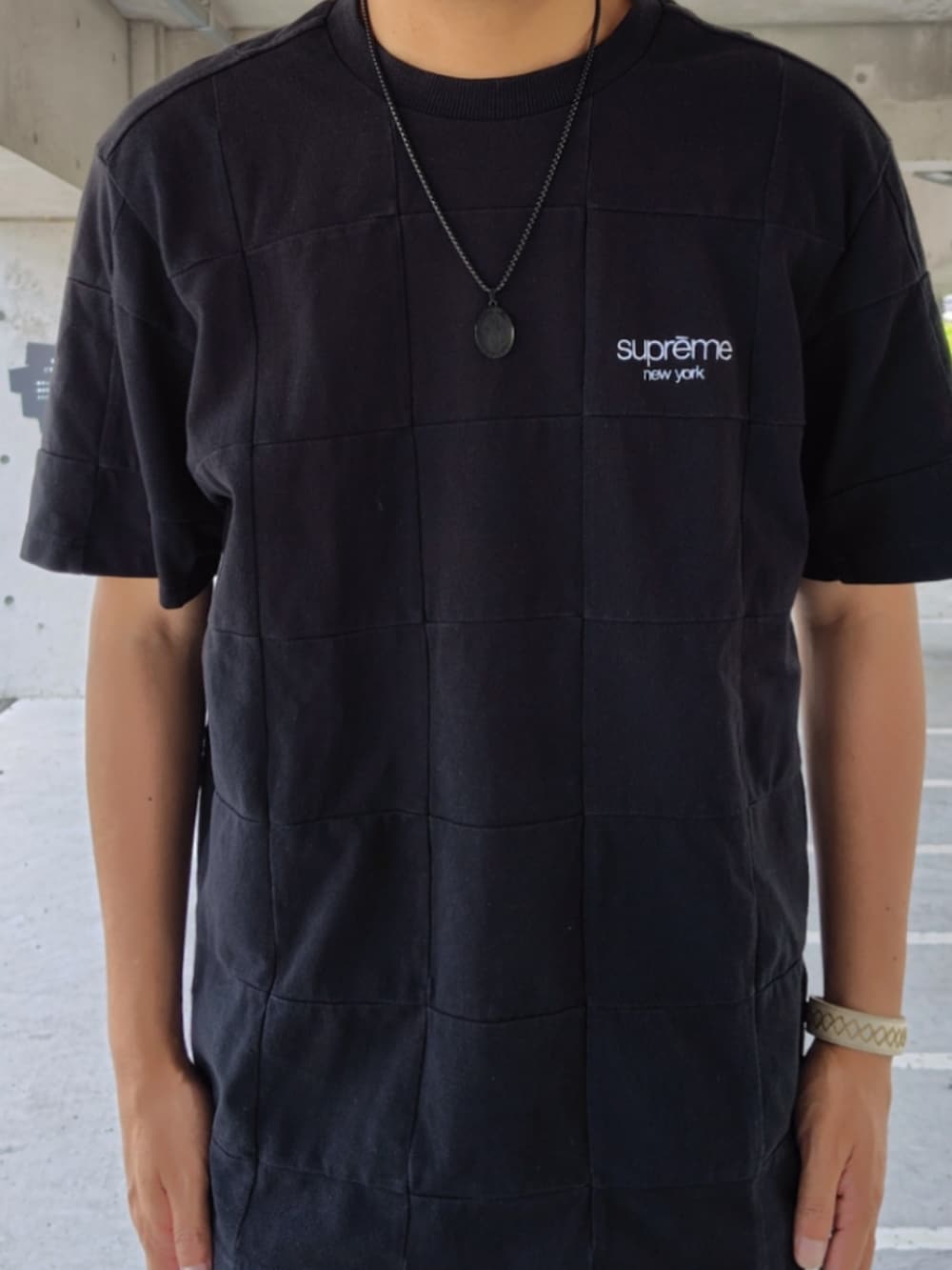 ブラック系のTシャツ/カットソー、ブルー系のデニムパンツ、ブラック系のスニーカーを着用したメンズの夏コーディネートの3枚目の写真