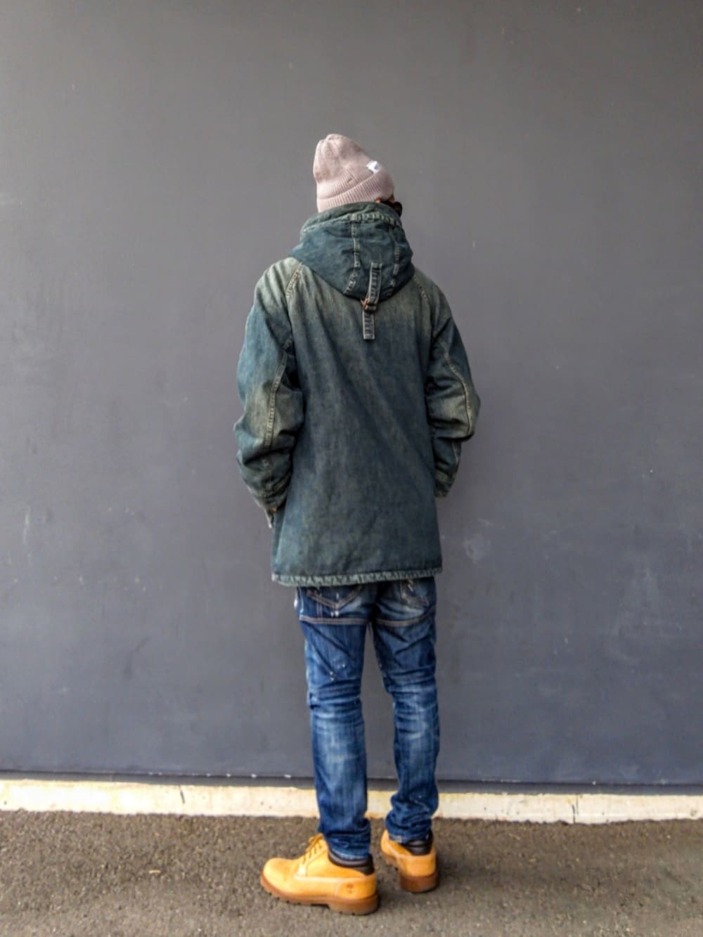 ブルー系のミリタリージャケット、ブルー系のデニムパンツ、イエロー系のブーツを着用したメンズの冬コーディネートの3枚目の写真