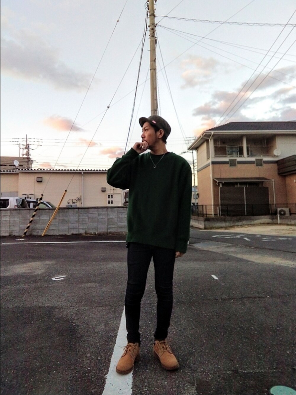 グリーン系のスウェット、ブルー系のデニムパンツ、イエロー系のブーツを着用したメンズの秋コーディネートの2枚目の写真