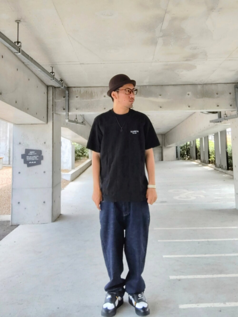 ブラック系のTシャツ/カットソー、ブルー系のデニムパンツ、ブラック系のスニーカーを着用したメンズの夏コーディネートの2枚目の写真