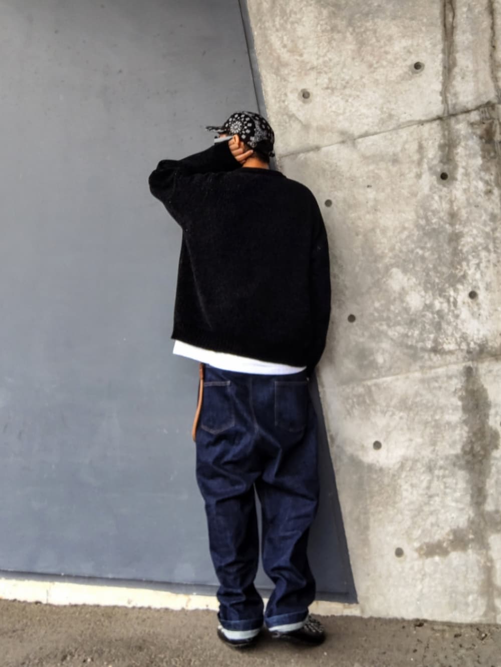 ブラック系のニット/セーター、ブルー系のデニムパンツ、ブラック系のその他シューズを着用したメンズの冬コーディネートの3枚目の写真