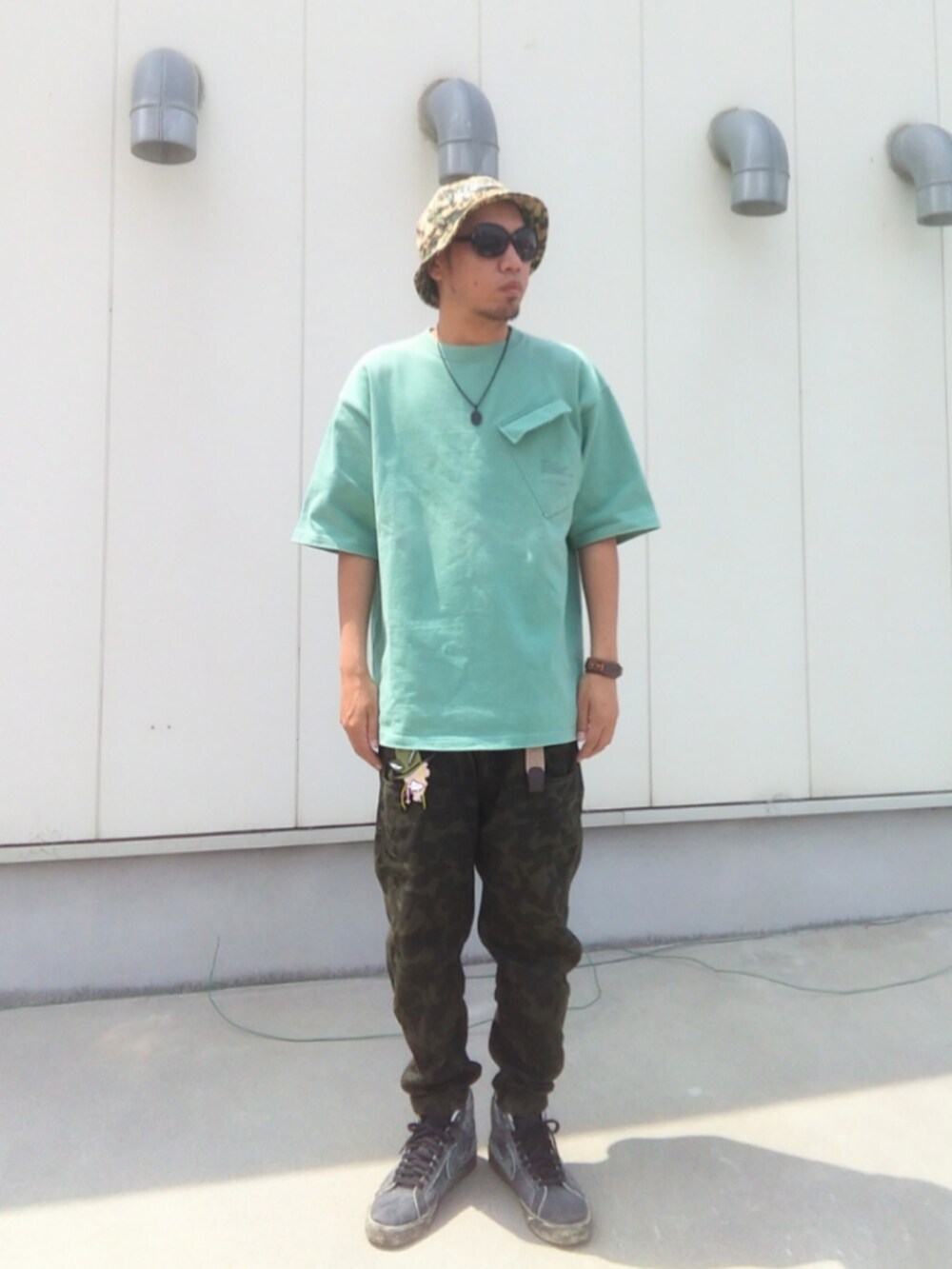 グリーン系のTシャツ/カットソー、その他のパンツ、ブラック系のスニーカーを着用したメンズの夏コーディネートの3枚目の写真