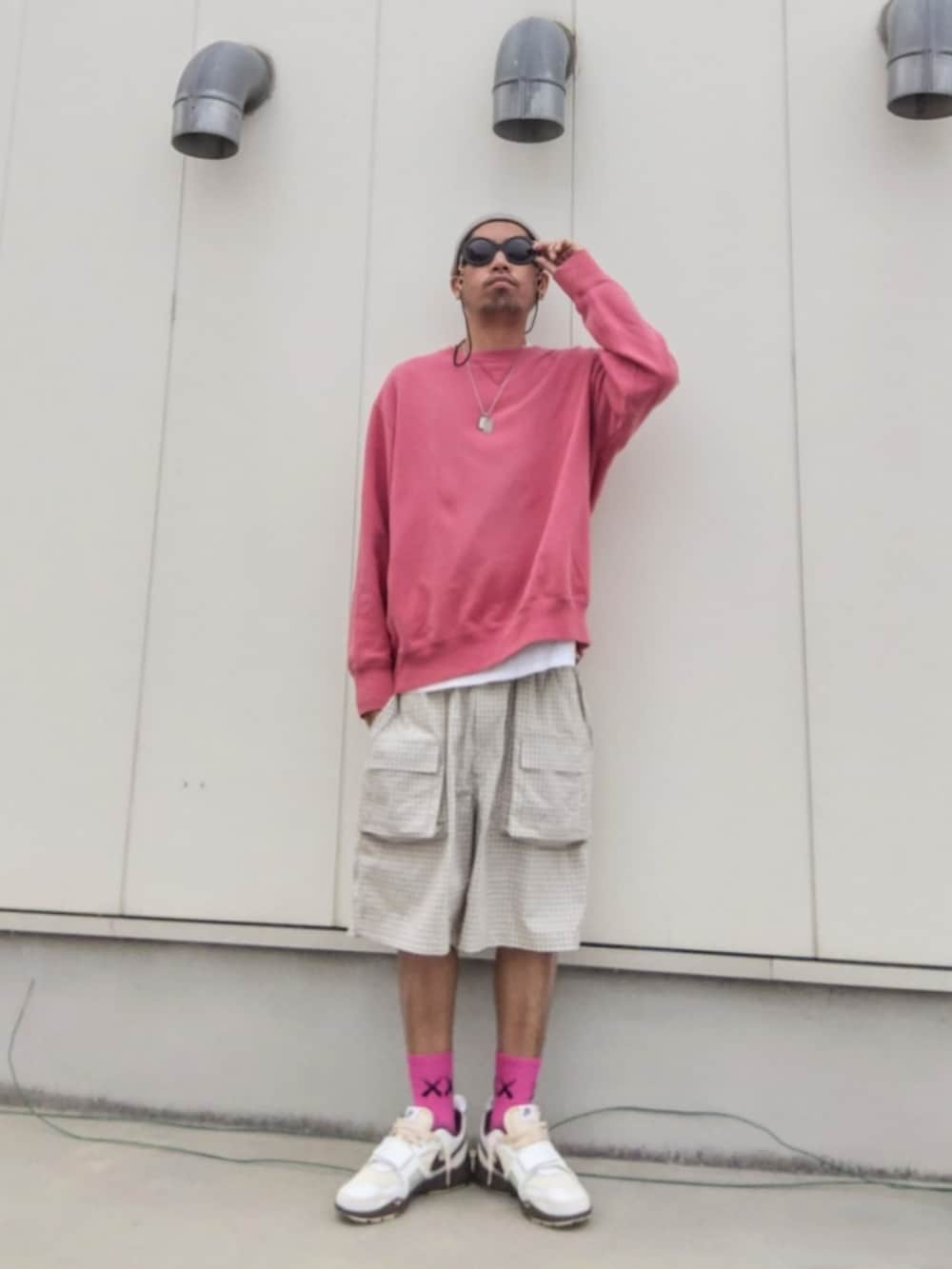 ピンク系のスウェット、ホワイト系のパンツ、ブラウン系のスニーカーを着用したメンズの春コーディネートの2枚目の写真