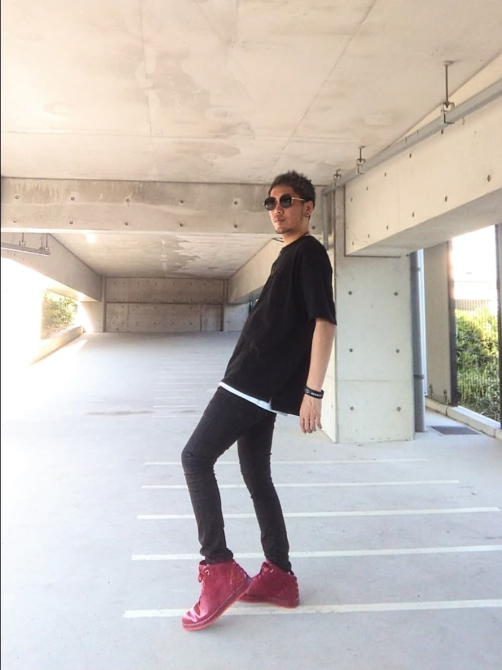 ブラック系のTシャツ/カットソー、ブラック系のデニムパンツ、レッド系のスニーカーを着用したメンズの夏コーディネートの2枚目の写真
