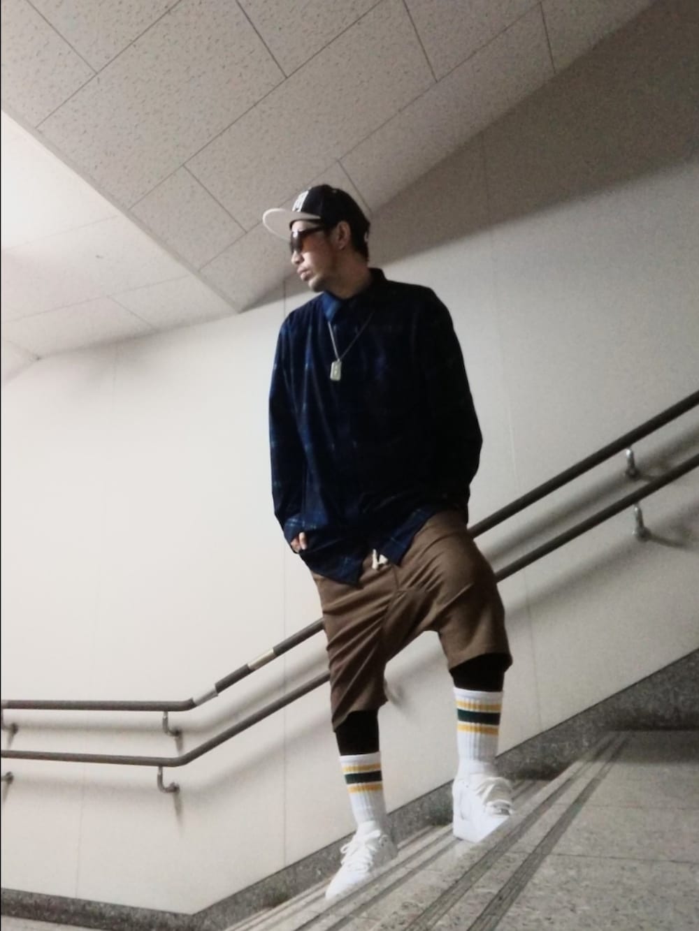 ブルー系のシャツ/ブラウス、ブラウン系のその他パンツ、ホワイト系のスニーカーを着用したメンズの春コーディネートの2枚目の写真