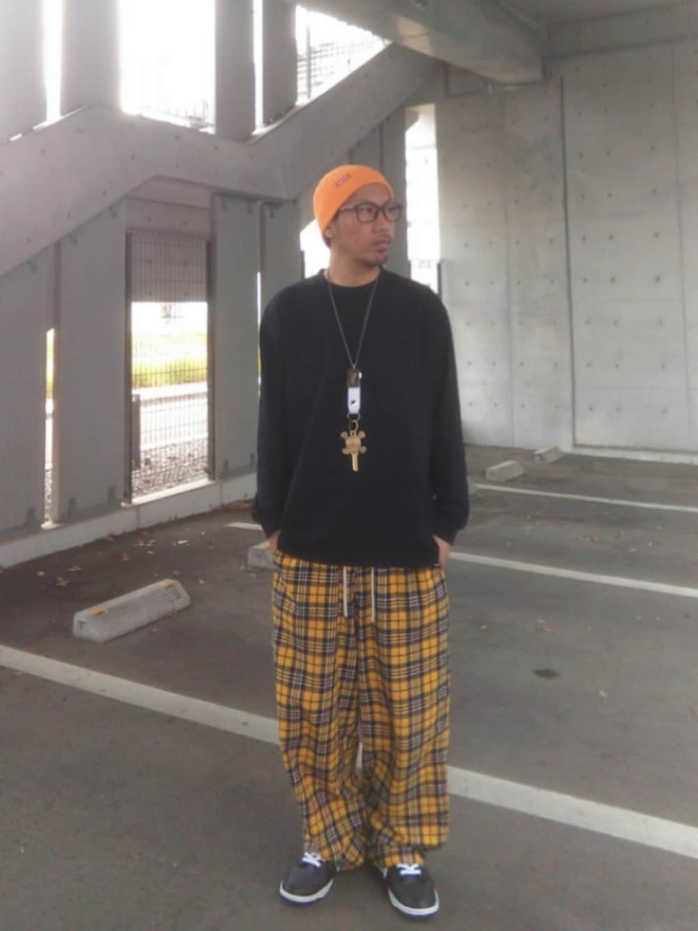 ブラック系のTシャツ/カットソー、イエロー系のその他パンツ、ブラック系のスニーカーを着用したメンズの春コーディネートの2枚目の写真