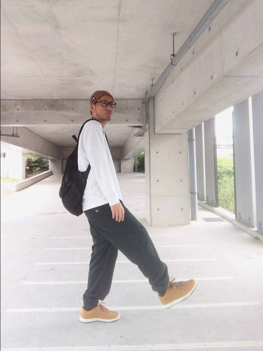 ブラウン系のスニーカー、ブラック系のスウェットパンツ、ホワイト系のTシャツ/カットソーを着用したメンズの春コーディネートの2枚目の写真