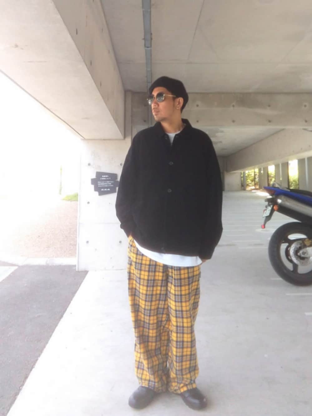 ブラック系のジャケット/アウター、イエロー系のその他パンツ、ブラック系のブーツを着用したメンズの春コーディネートの2枚目の写真