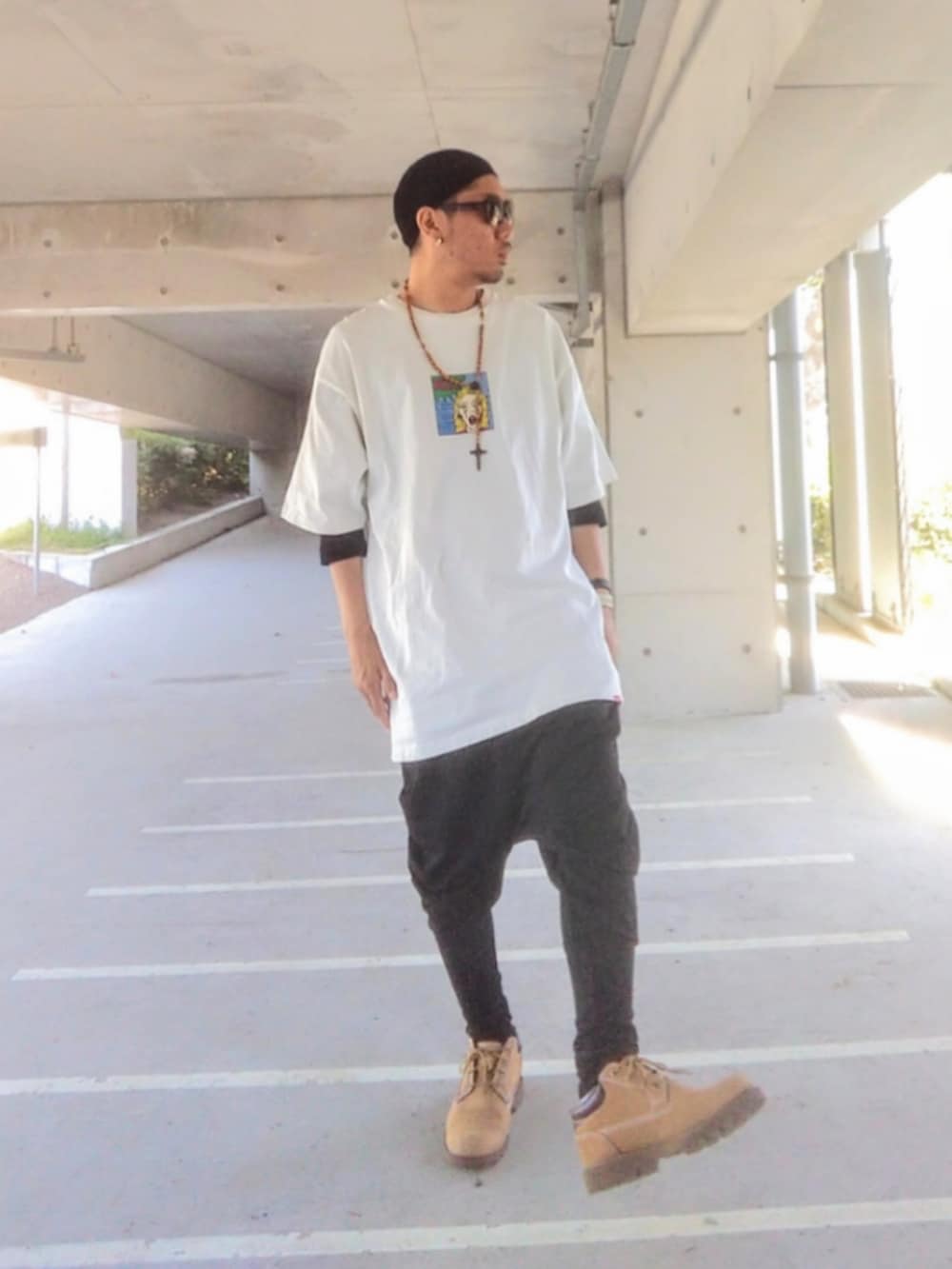 ホワイト系のTシャツ/カットソー、ブラック系のその他パンツ、イエロー系のブーツを着用したメンズの春コーディネートの2枚目の写真