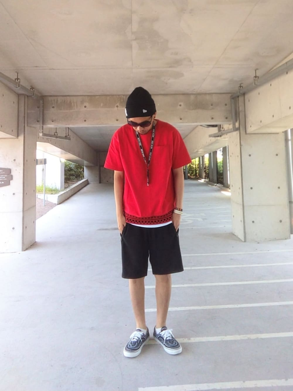 レッド系のTシャツ/カットソー、ブラック系のその他パンツ、ブラック系のスニーカーを着用したメンズの夏コーディネートの2枚目の写真