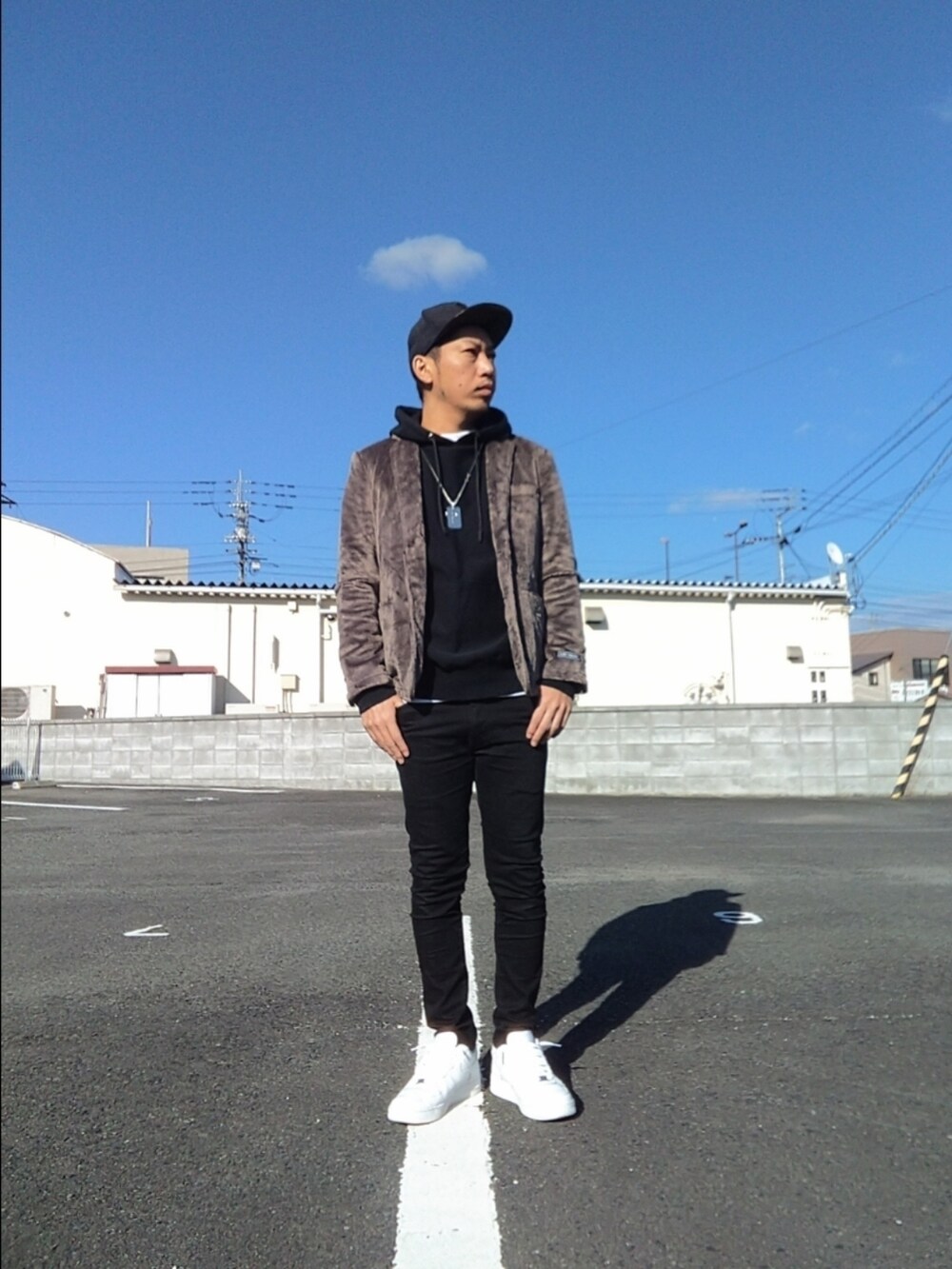 ホワイト系のスニーカー、ブラック系のデニムパンツ、ブラック系のパーカーを着用したメンズの冬コーディネートの2枚目の写真
