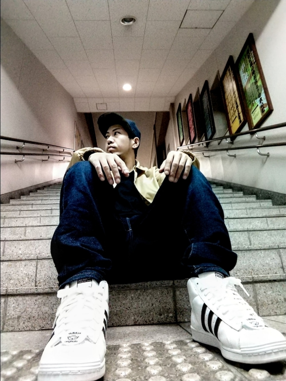 ベージュ系のナイロンジャケット、ブルー系のデニムパンツ、ホワイト系のスニーカーを着用したメンズの秋コーディネートの2枚目の写真