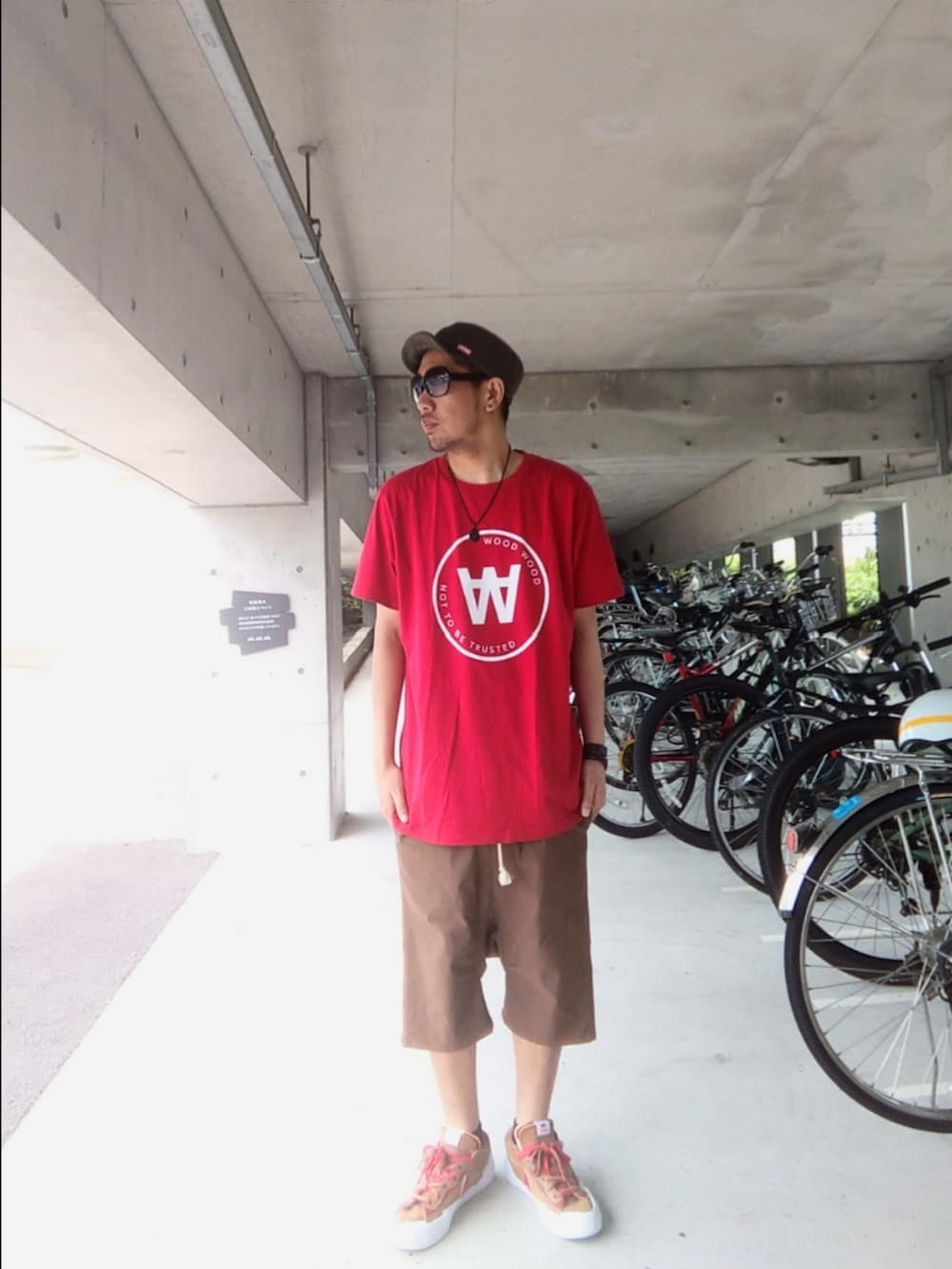 レッド系のTシャツ/カットソー、ブラウン系のその他パンツ、ブラウン系のスニーカーを着用したメンズの夏コーディネートの3枚目の写真