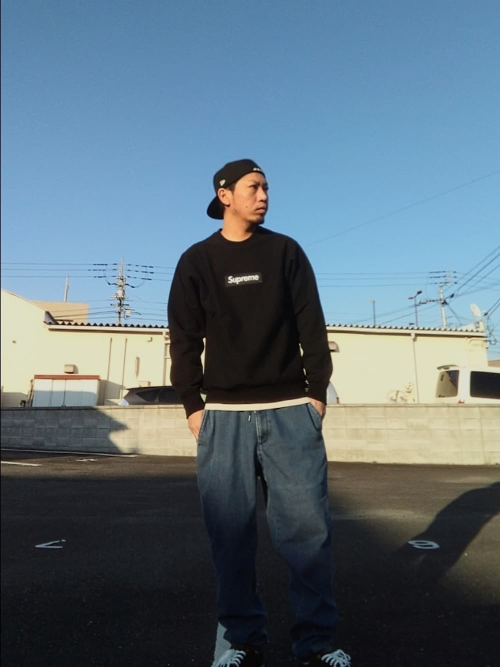 ブラック系のスウェット、ブルー系のデニムパンツ、ブラック系のスニーカーを着用したメンズの冬コーディネートの2枚目の写真