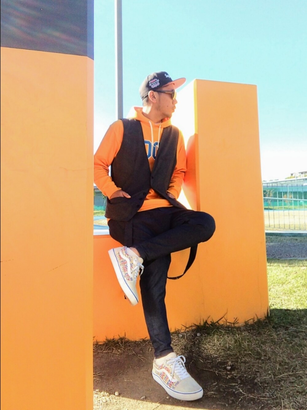 イエロー系のパーカー、グレー系のベスト、ブルー系のその他パンツを着用したメンズの秋コーディネートの2枚目の写真