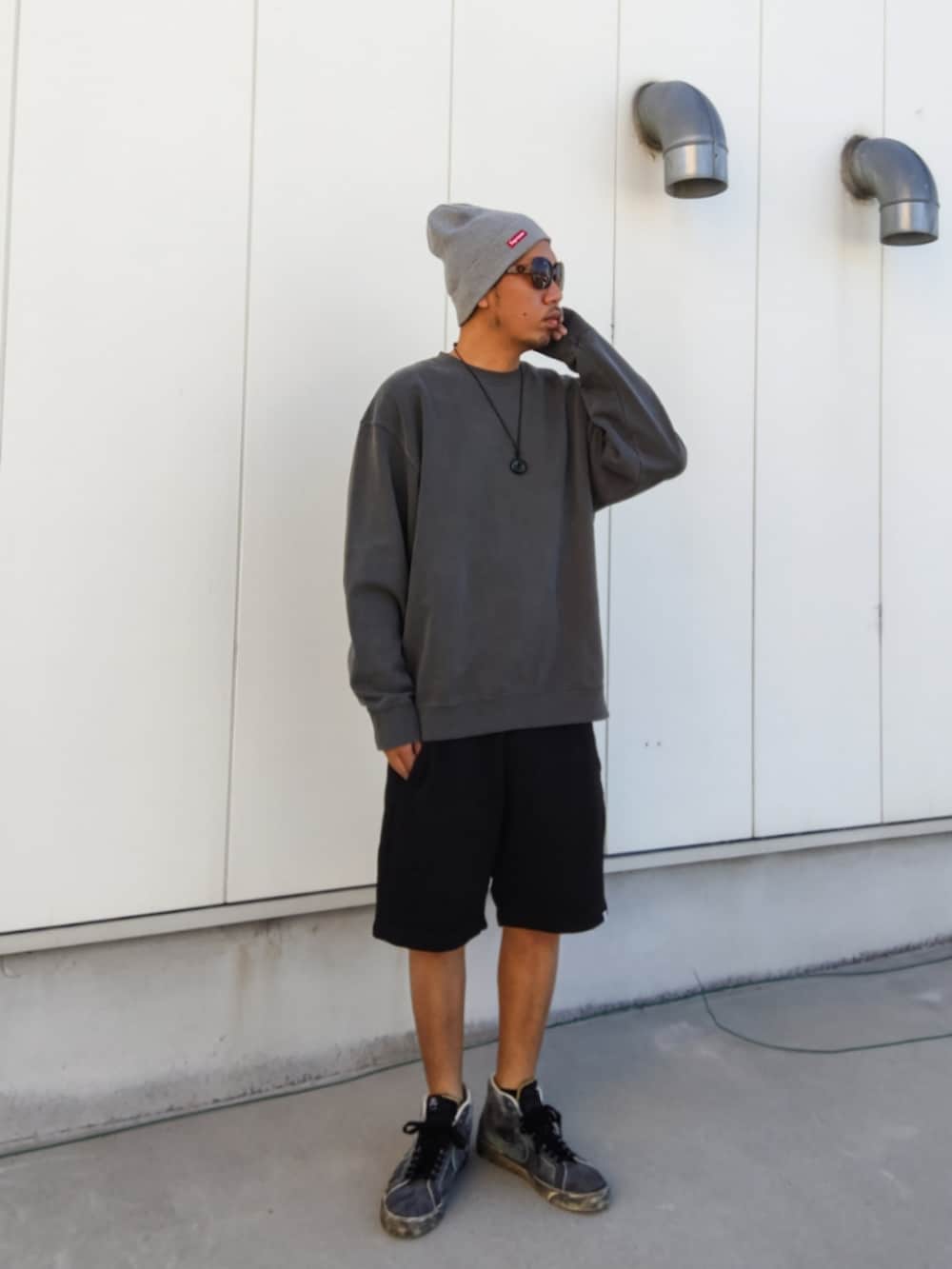 グレー系のスウェット、ブラック系のその他パンツ、ブラック系のスニーカーを着用したメンズの秋コーディネートの2枚目の写真