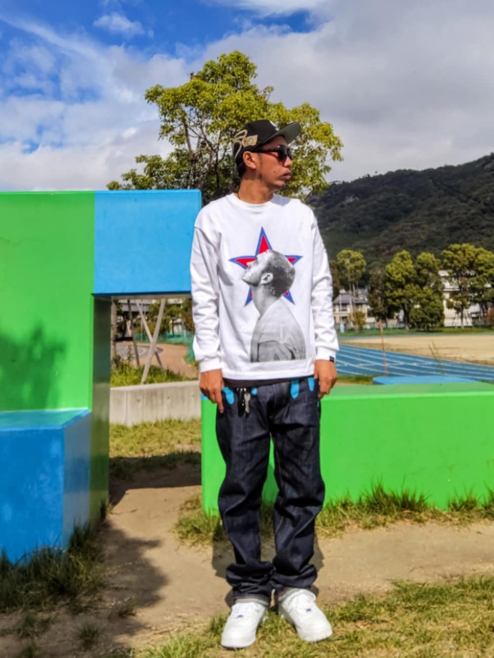 ホワイト系のTシャツ/カットソー、ブラック系のタンクトップ、ブルー系のデニムパンツを着用したメンズの秋コーディネートの2枚目の写真