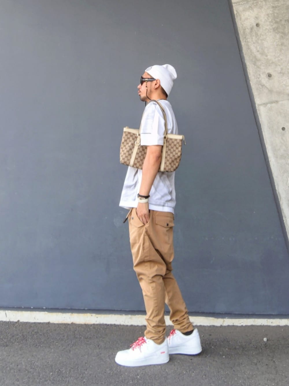 ホワイト系のTシャツ/カットソー、ベージュ系のトートバッグ、ベージュ系のその他パンツを着用したメンズの夏コーディネートの3枚目の写真