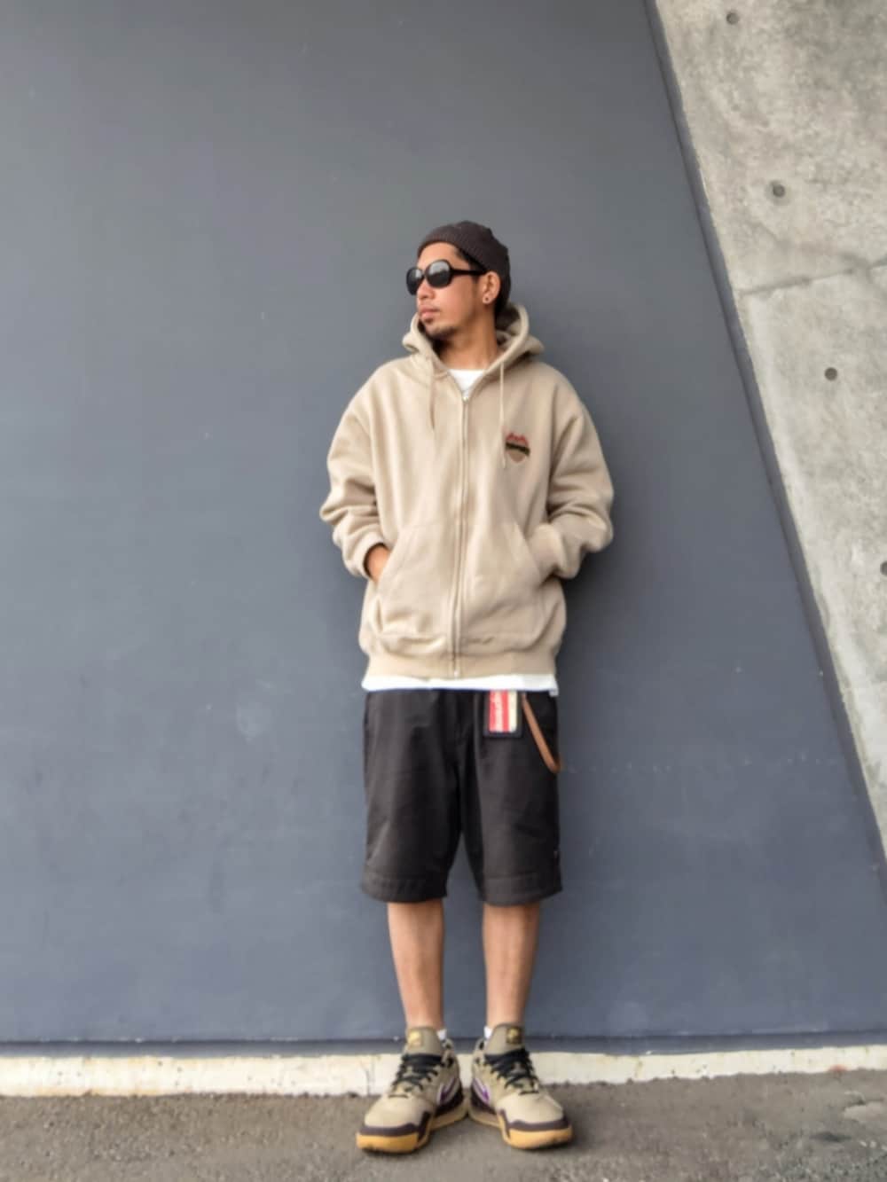 ベージュ系のパーカー、ブラック系のその他パンツ、ベージュ系のスニーカーを着用したメンズの春コーディネートの3枚目の写真